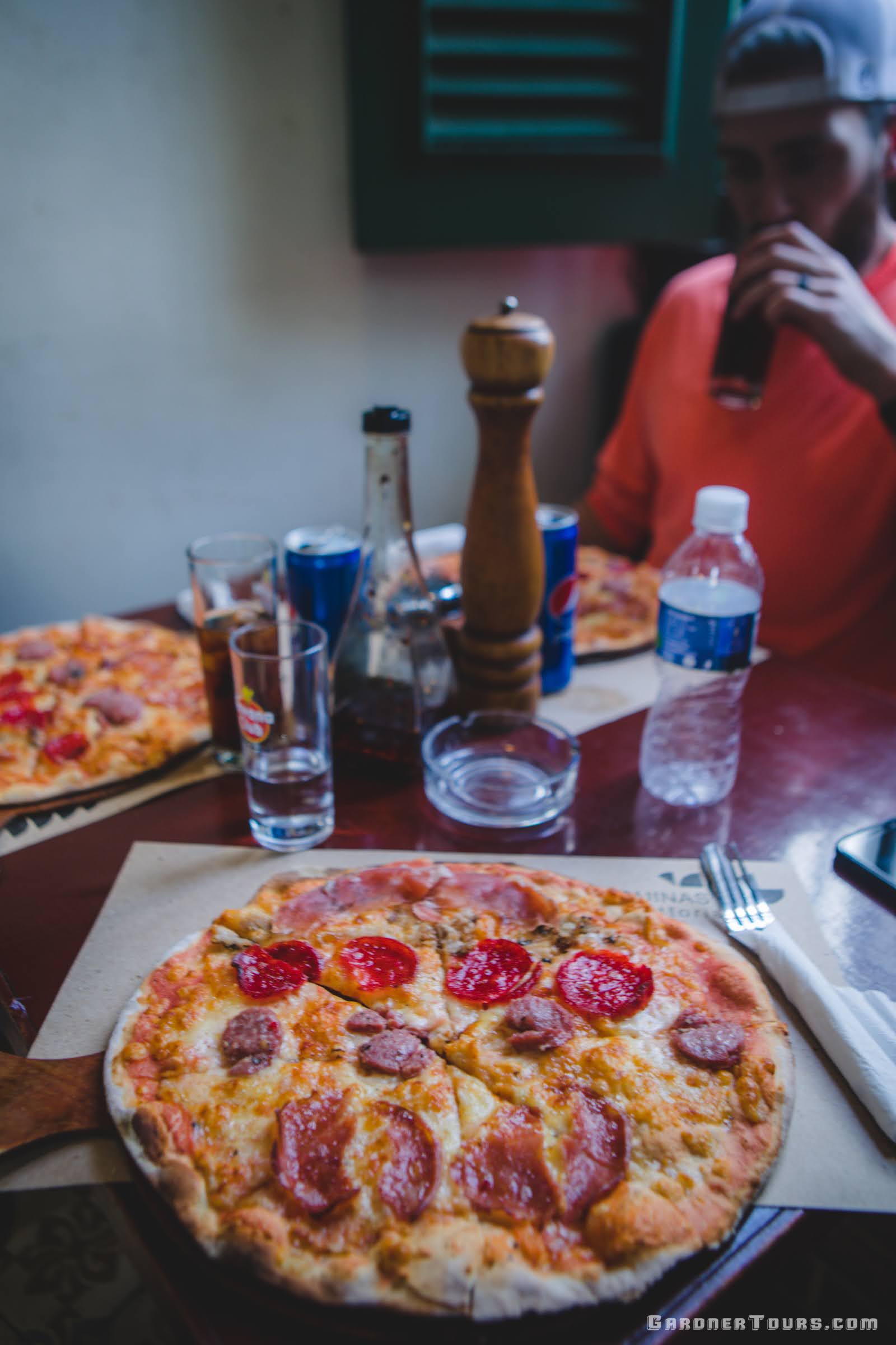 Eating a Charcuteria Meat Pizza at Restaurant Paladar 5 Esquinas Trattoria in Old Havana, Cuba