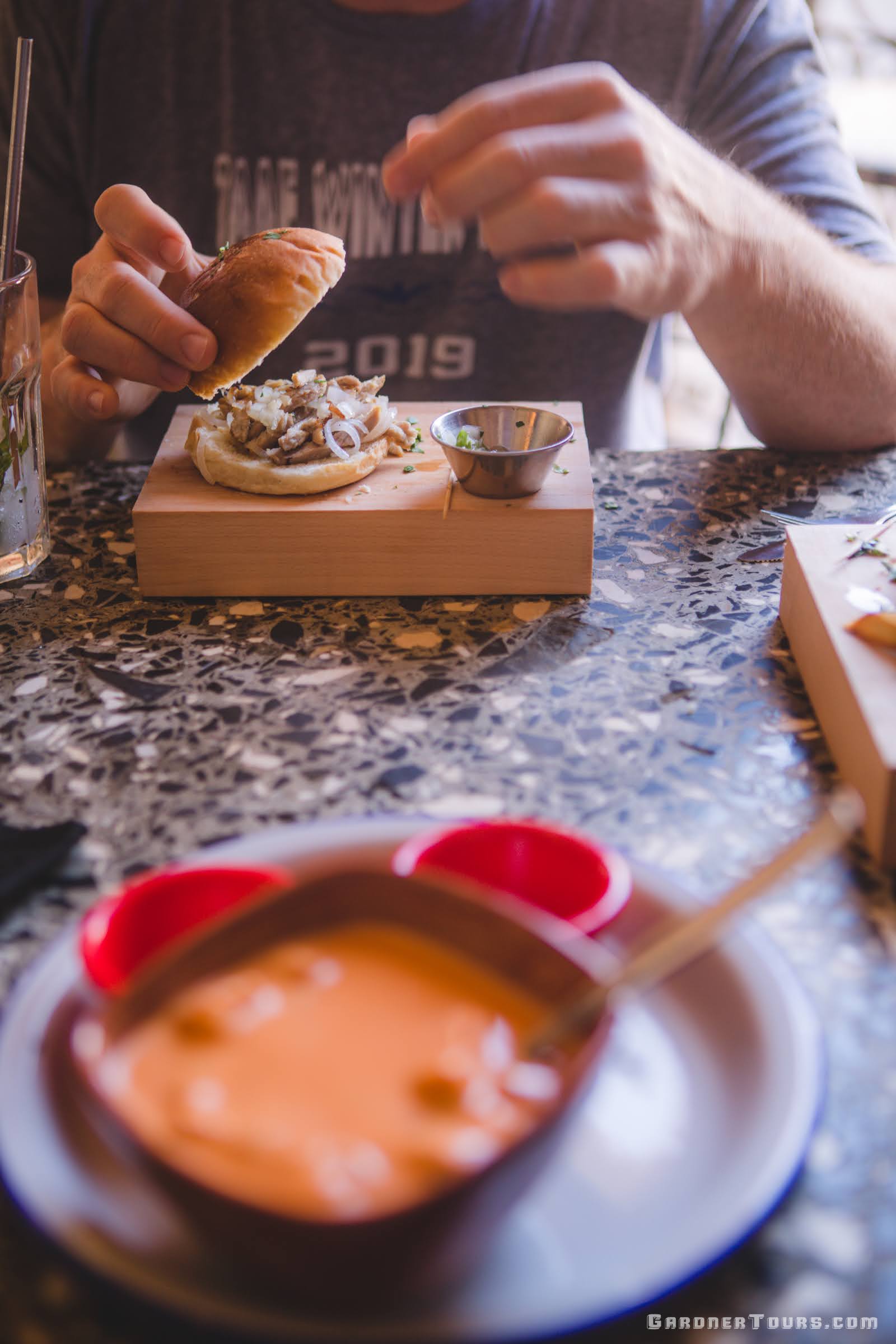 A man eating a pork lechon sandwich at Restaurant Paladar El Dandy in Old Havana, Cuba