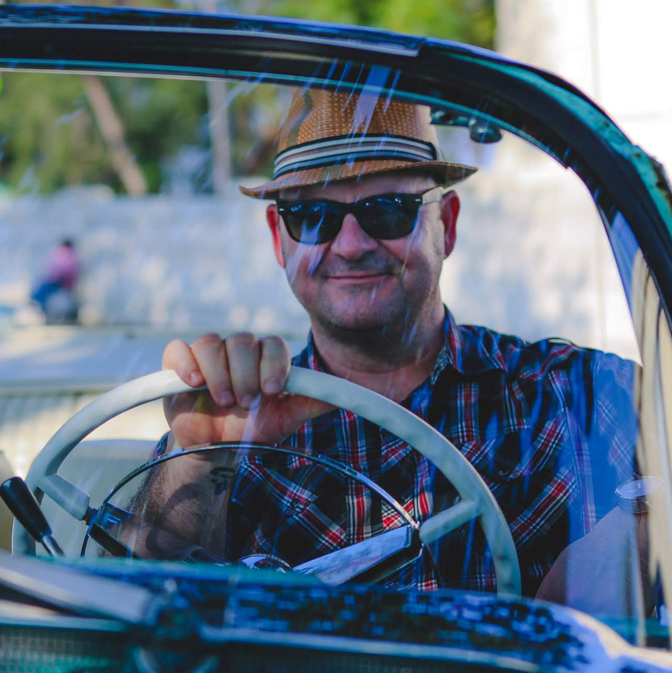 Gardner Tours Custom Cuba Tour Man Posing behind the wheel of a beautiful Classic Car in Havana Cuba