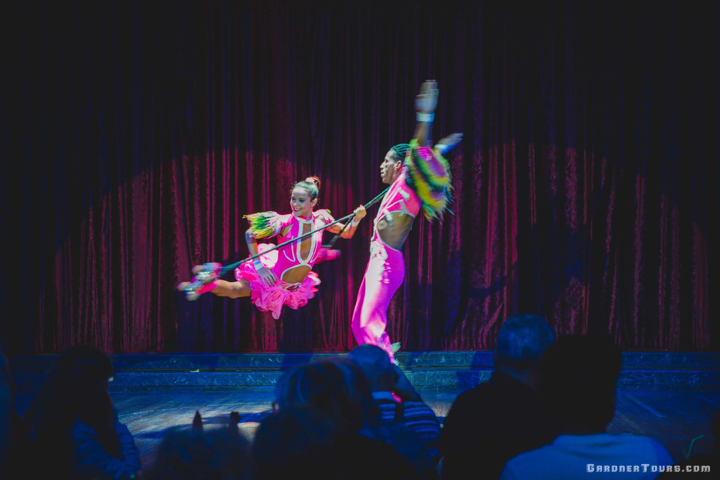 A woman and man acrobat spinning around in a circle on roller skates at the Cabaret Parisien's Big Show in the Hotel Nacional in Havana, Cuba