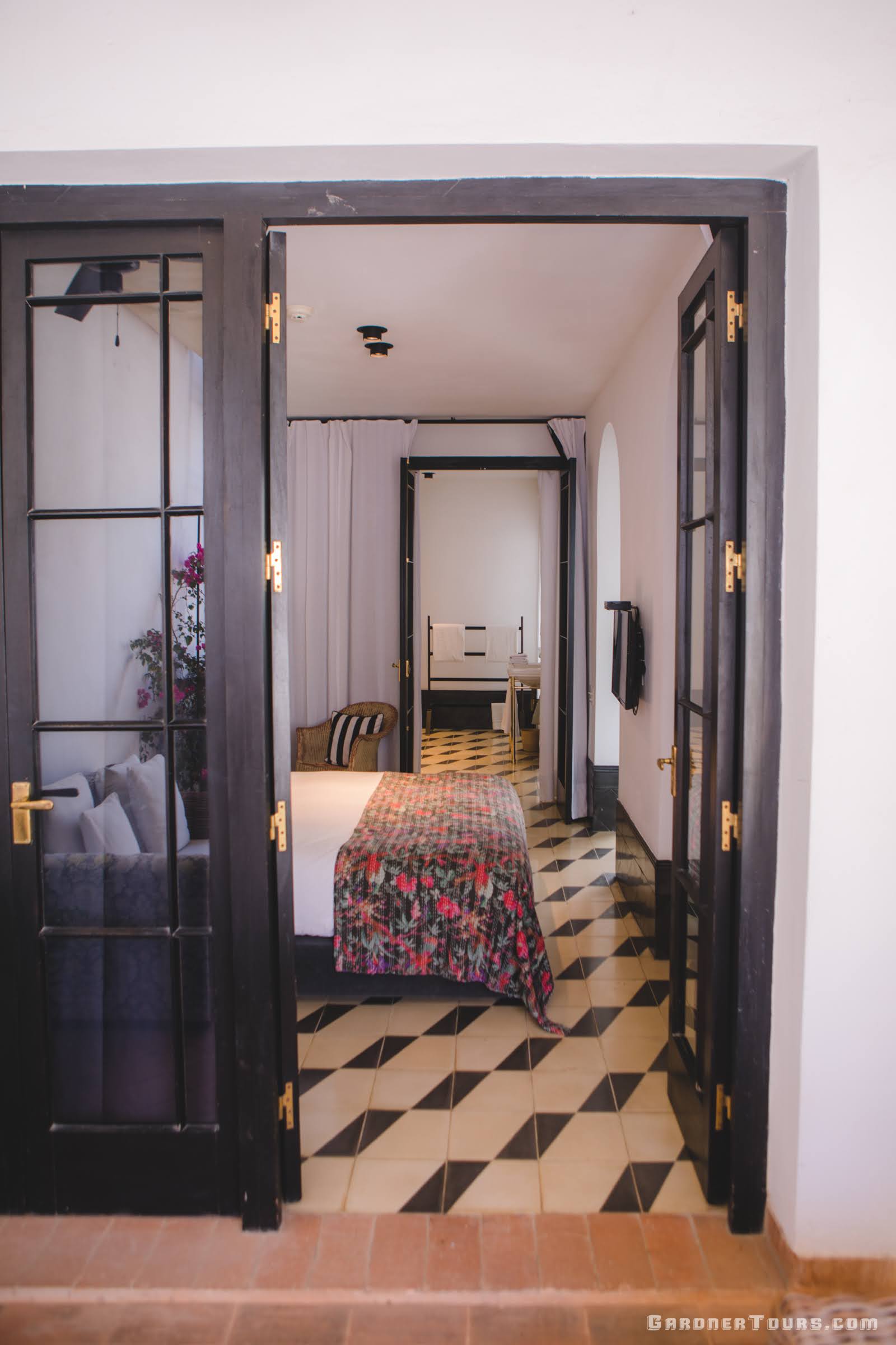 View, from the Terrace, of the Luxury Bedroom with Lush Bed and Black, White, and Purple/Pink Flowered Decor at 5-star Luxury Accommodations in Old Havana, Cuba