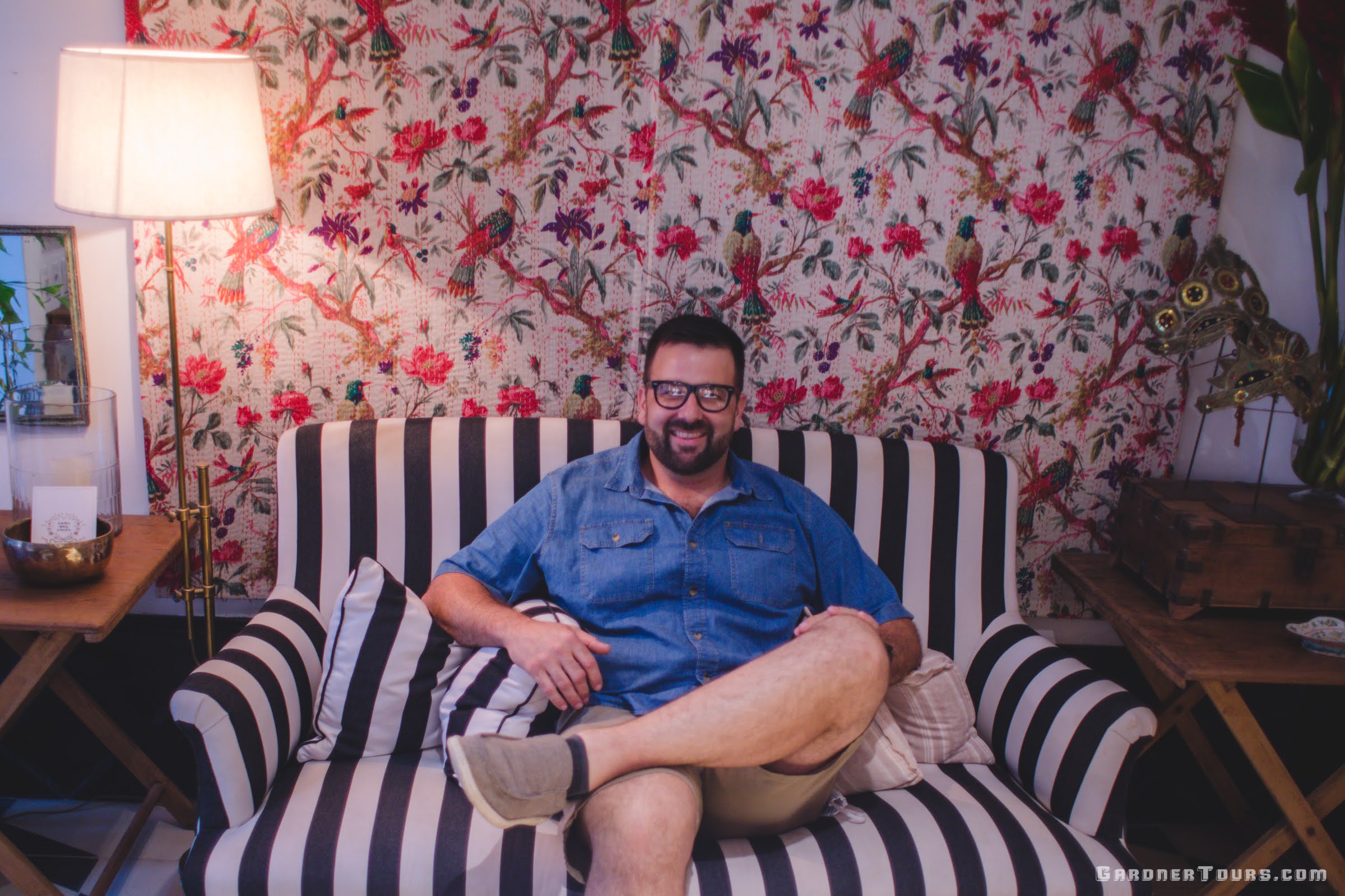 Gardner Tours Owner and Tour Guide Colby Gardner sitting on the black and white striped couch at the entrance of our 5-star Luxury Accommodations in Old Havana, Cuba