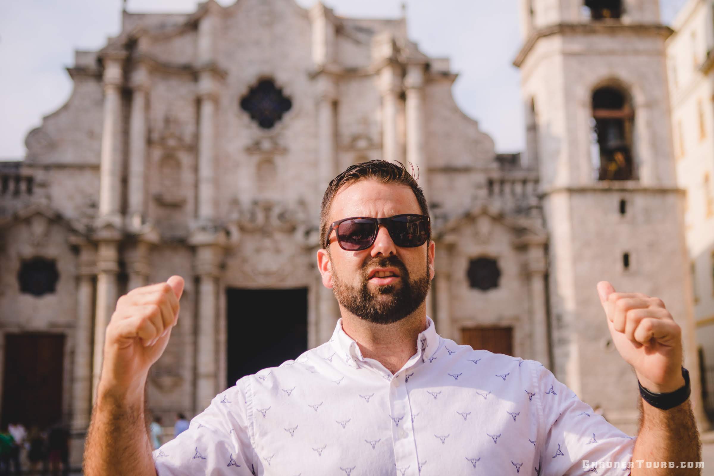 Gardner Tours Owner and Tour Guide Colby Gardner talking about the Cathedral of Havana, behind him, in Old Havana, Cuba