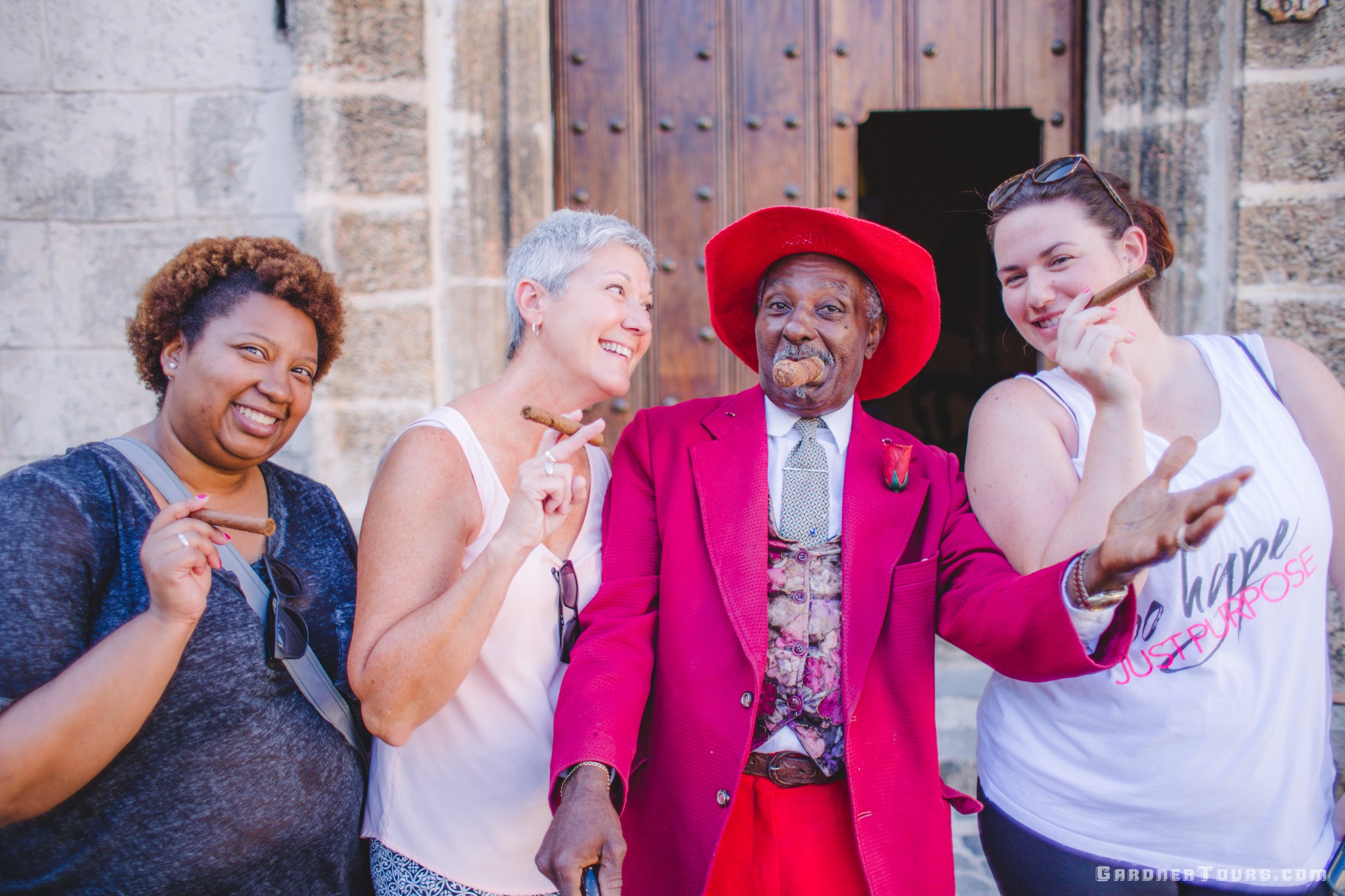 Three American Women Posing with an elderly Street Performer in Front of the Havana Cathedral in Old Havana, Cuba