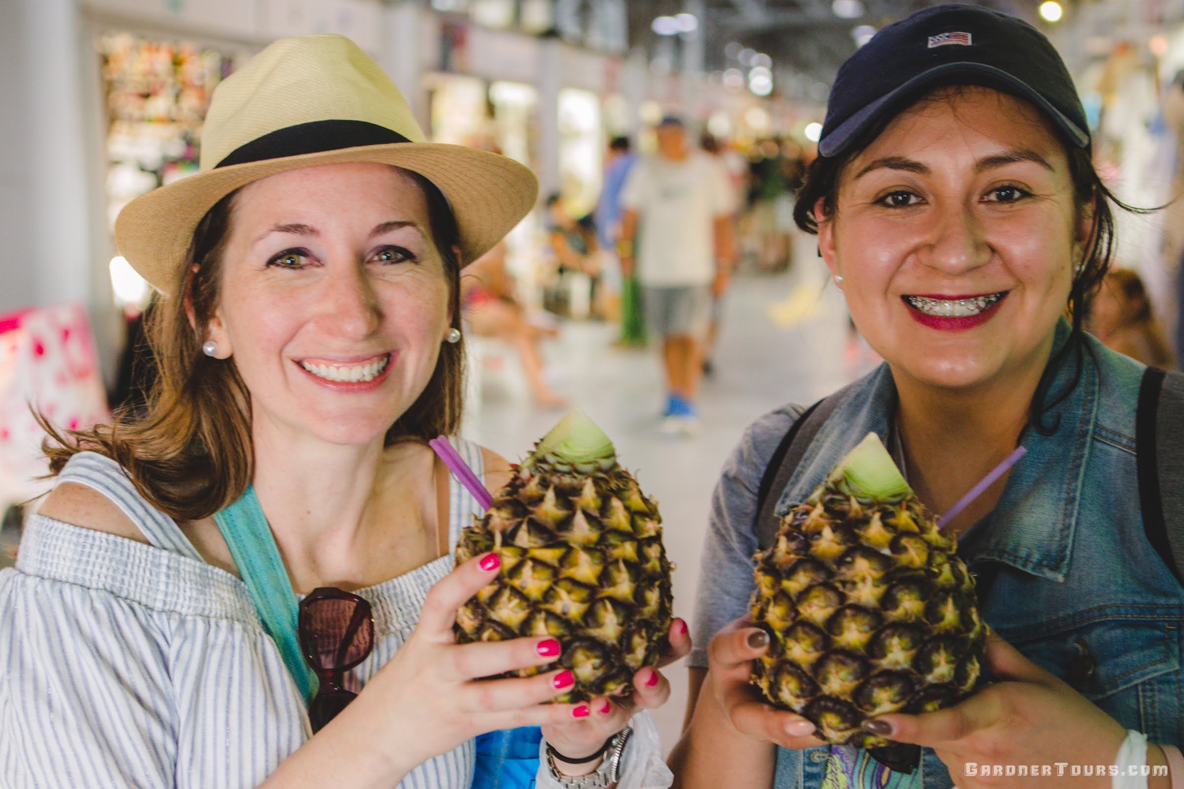 Gardner Tours Premium Cuba Cigar Tour Two Beautiful Ladies Drinking out of Pineapples at the Almacen San Jose in Old Havana