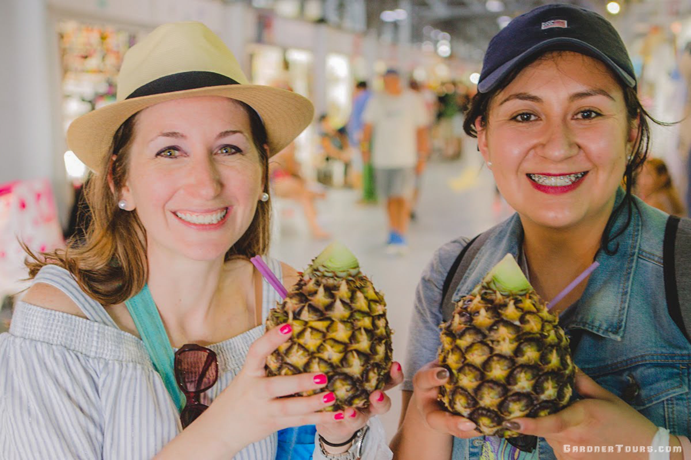 Gardner Tours Premium Cuba Cigar Tour Two Beautiful Ladies Drinking out of Pineapples at the Almacen San Jose in Old Havana