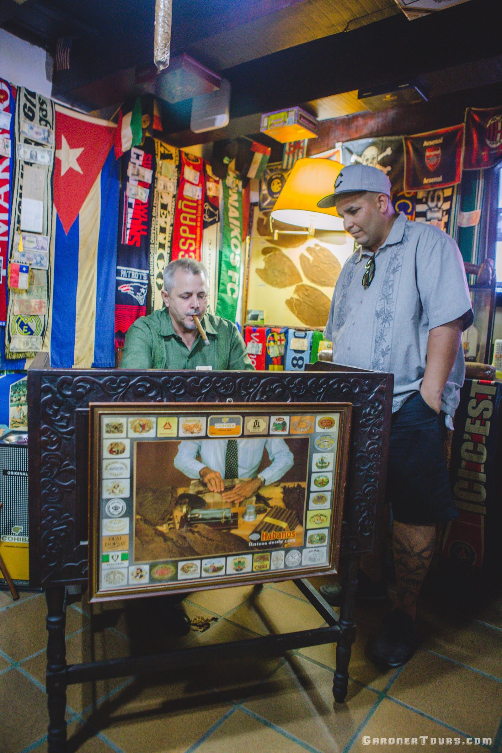 Gardner Tours Cuban Tour Guide Albert translating what is happening during the rolling of a cigar at the Conde de Villanueva Cigar Shop in Old Havana Cuba