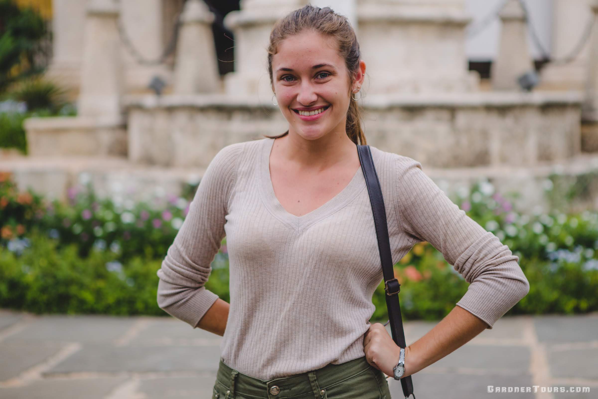 Gardner Tours Cuban Tour Guide Camila Posing with a big smile and a hand on her hip in front of El Templete in Plaza de Armas in Old Havana, Cuba