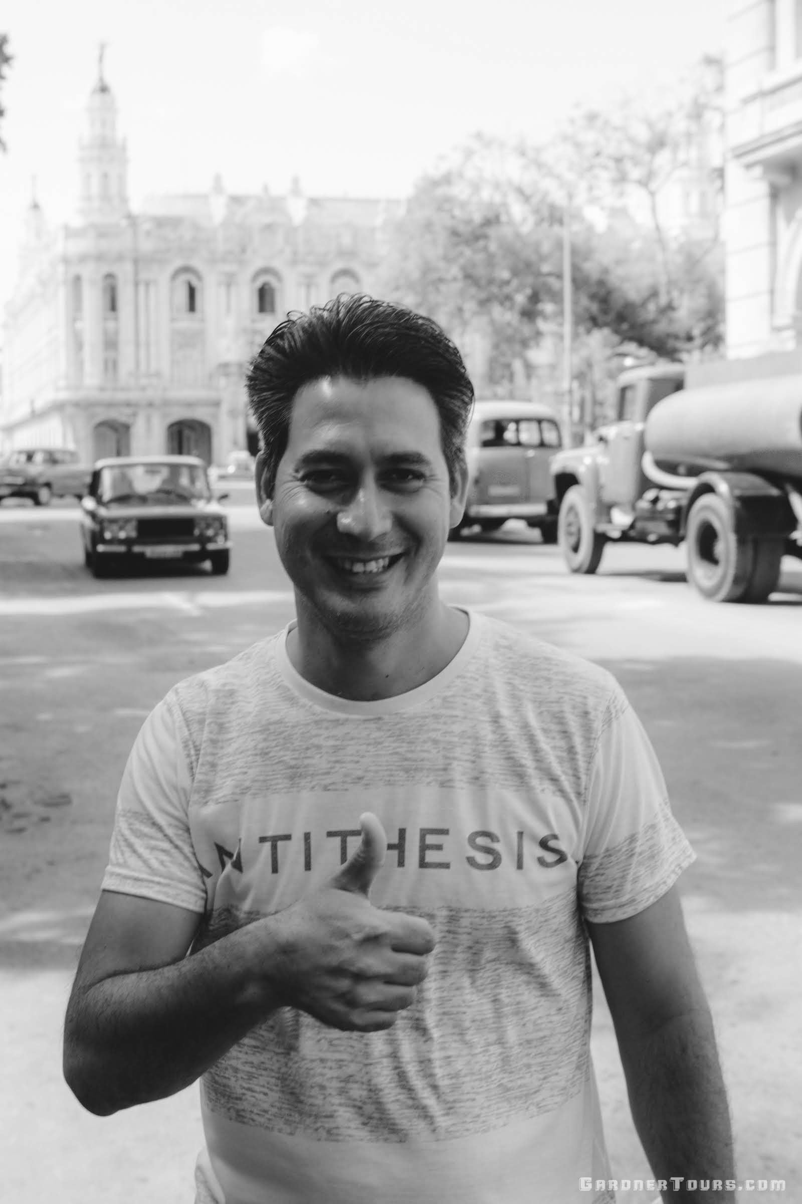 Gardner Tours Cuban Tour Guide Carlos giving a thumbs up in a black and white photo in the streets of Old Havana, Cuba