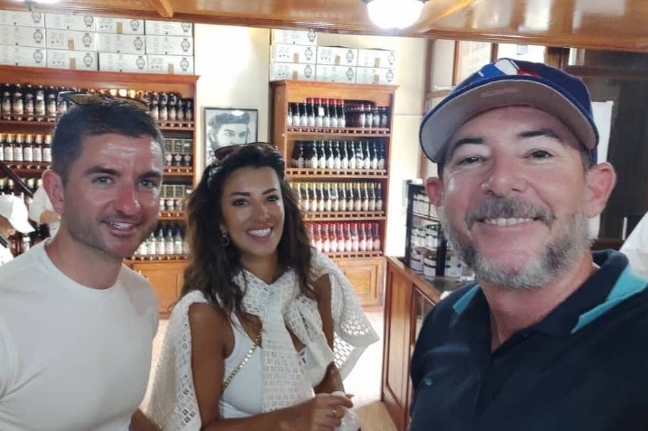 Gardner Tours Cuban Tour Guide Yedi smiling with his travelers from the UK at a liquor store in Havana, Cuba