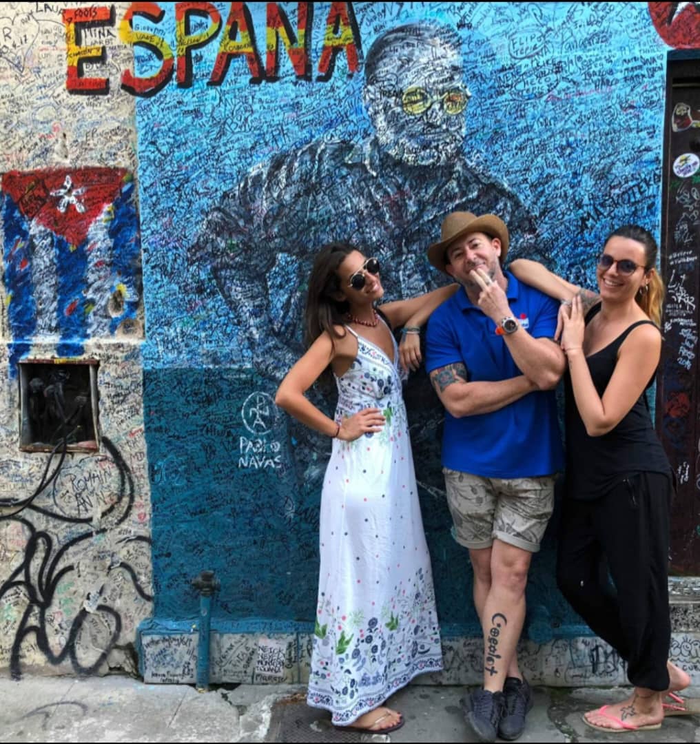 Gardner Tours Cuban Tour Guide posing with two woman travelers in front of La Bodegita del Medio in Havana, Cuba