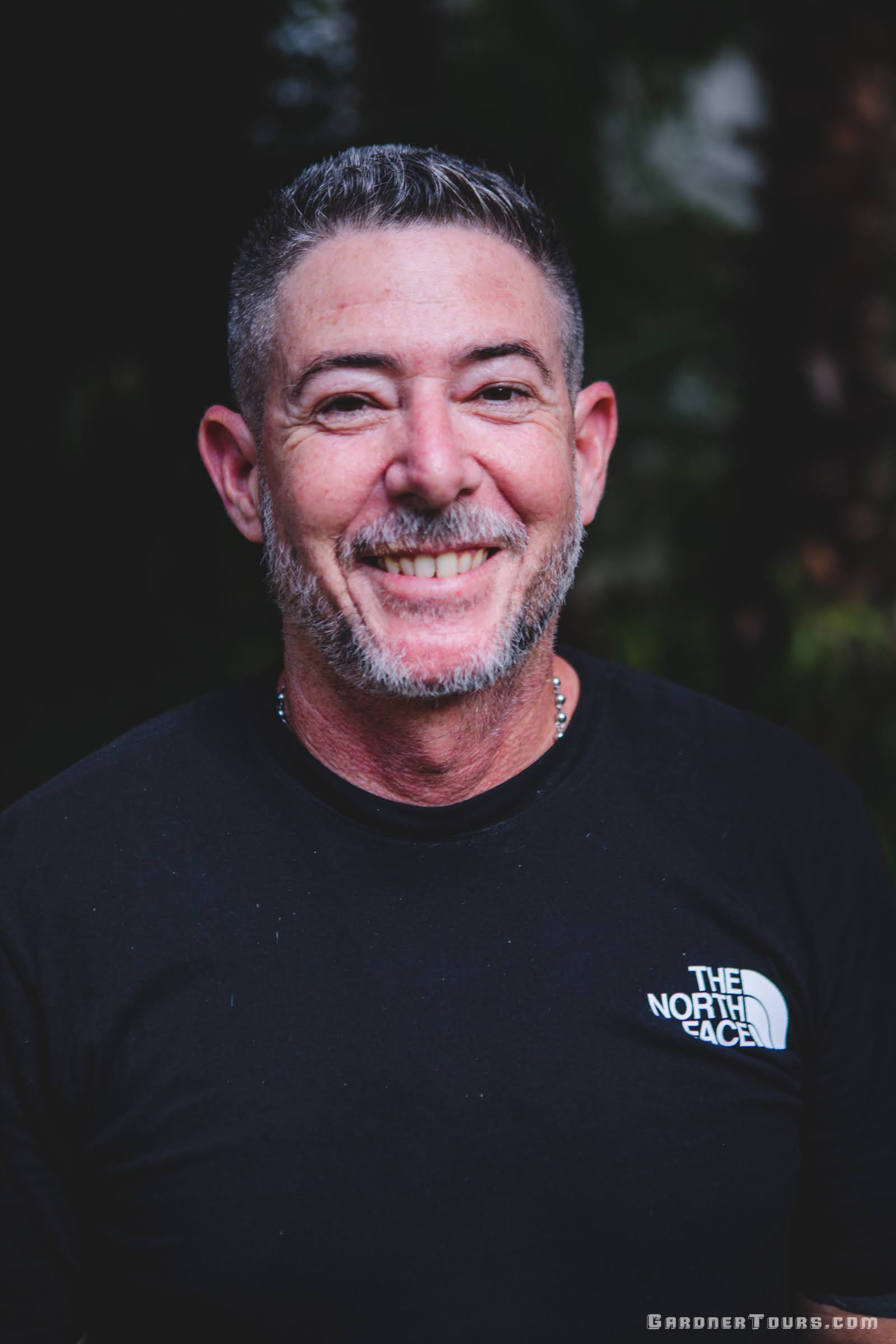 Gardner Tours Cuban Tour Guide Yedi wearing a black shirt and smiling at La Bodega in Vedado, Cuba