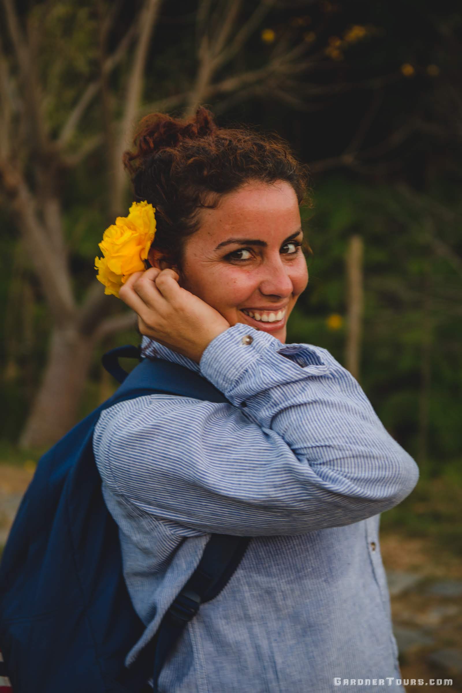 Gardner Tours Cuban Tour Guide Zeydi with a flower behind her ear and smiling in the Topes de Collantes National Park in Cuba