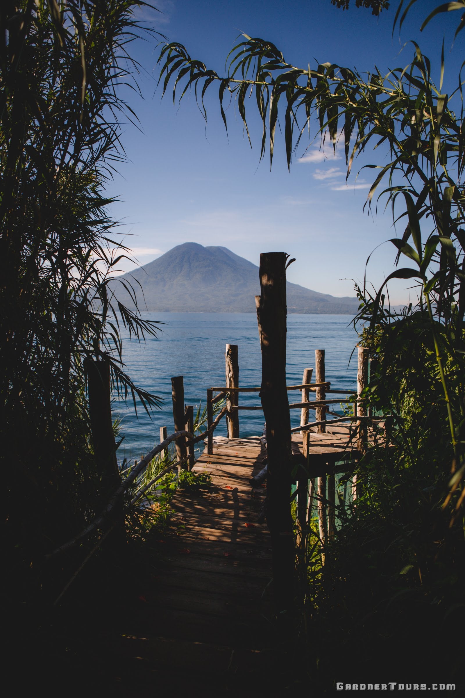 A breathtaking view of a volcano over Lake Atitlan in Guatemala, representing the diverse boutique destinations offered by Gardner Tours.