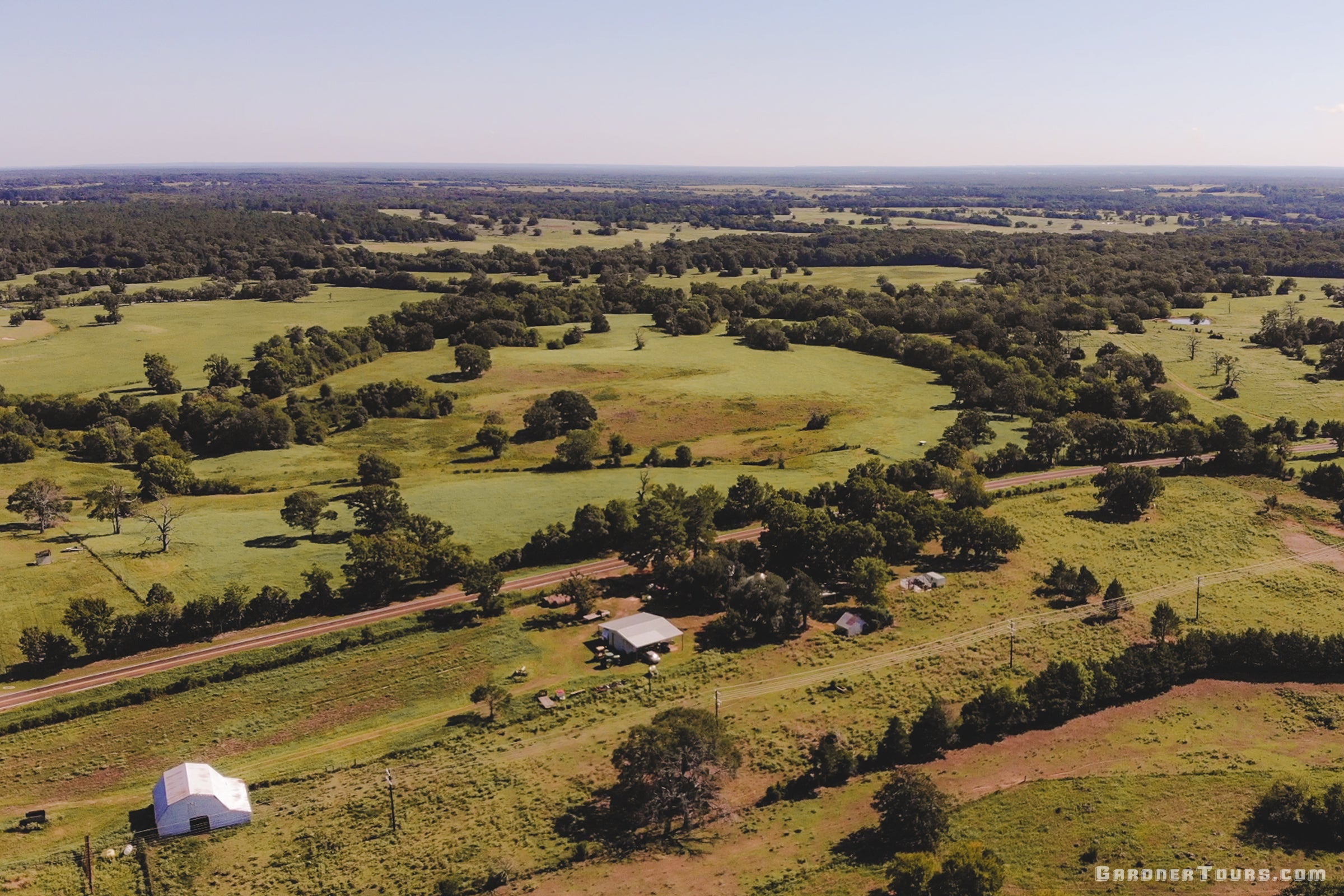 A scenic view of the Coleman Gardner Farm and Ranch, a rural landscape, showcasing open Texas pastureland and the heritage roots featured on Gardner Tours’ Texas Tours.