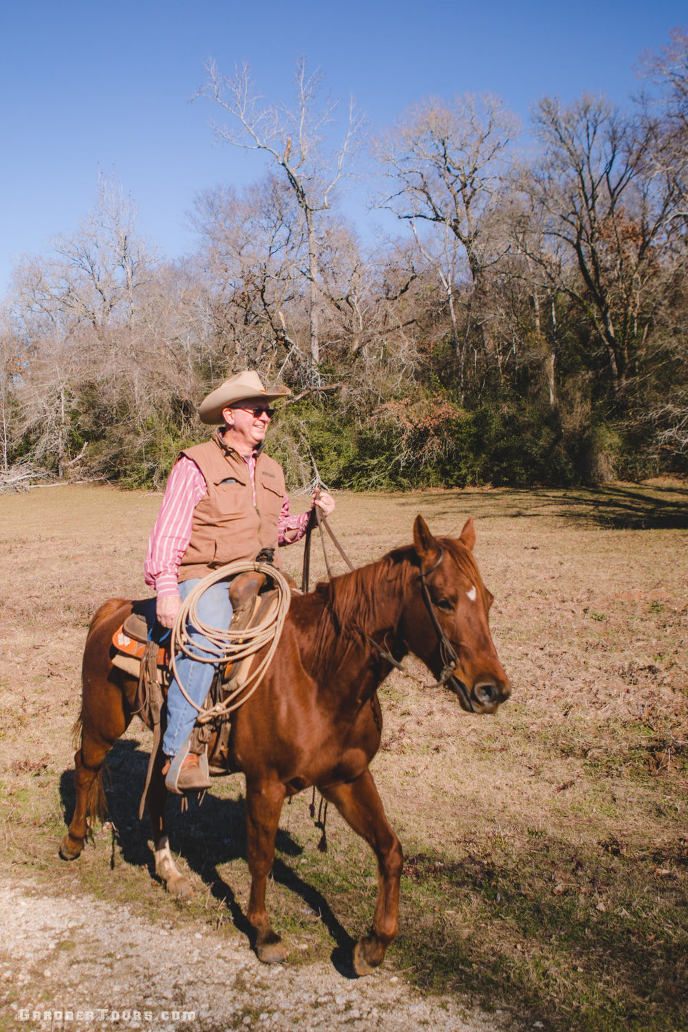 Older cowboy riding his horse on a ranch outside of Centerville, Texas.