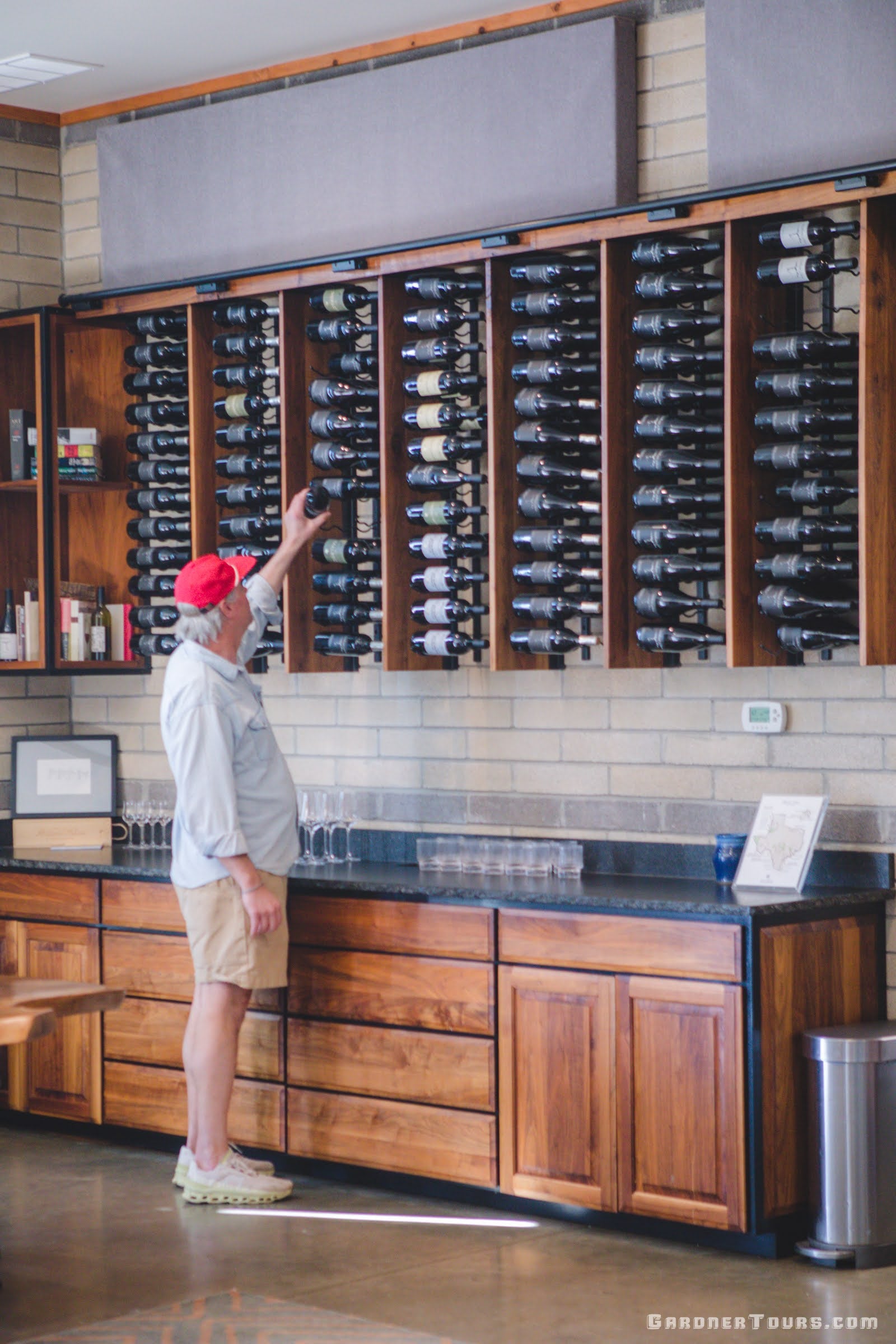 Chris Brundrett, co-owner of William Chris Vineyards, chooses a bottle of wine from their wine bottle room in Hye, Texas.