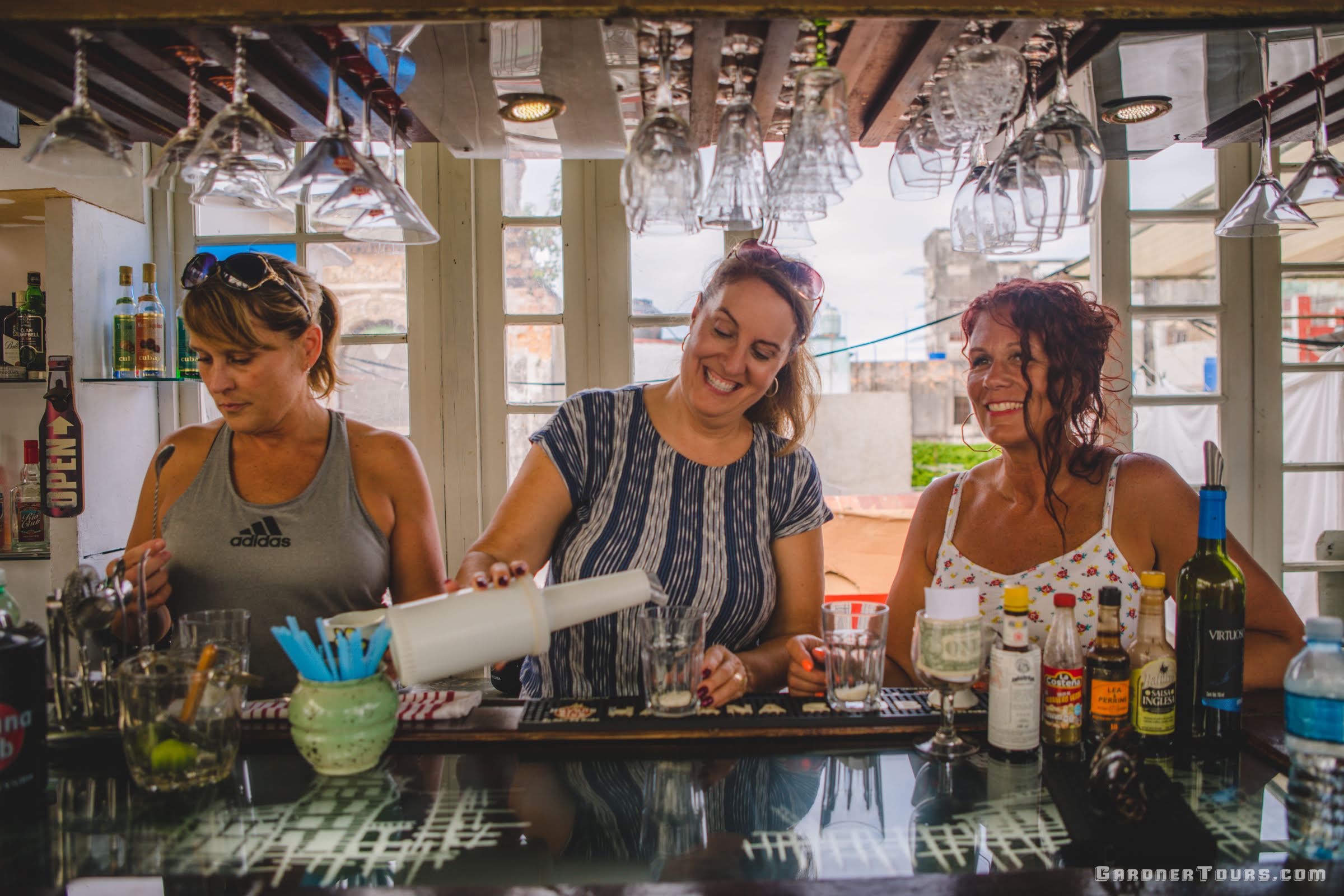 Three Women Enjoying Drinks At Bar In Havana Cuba