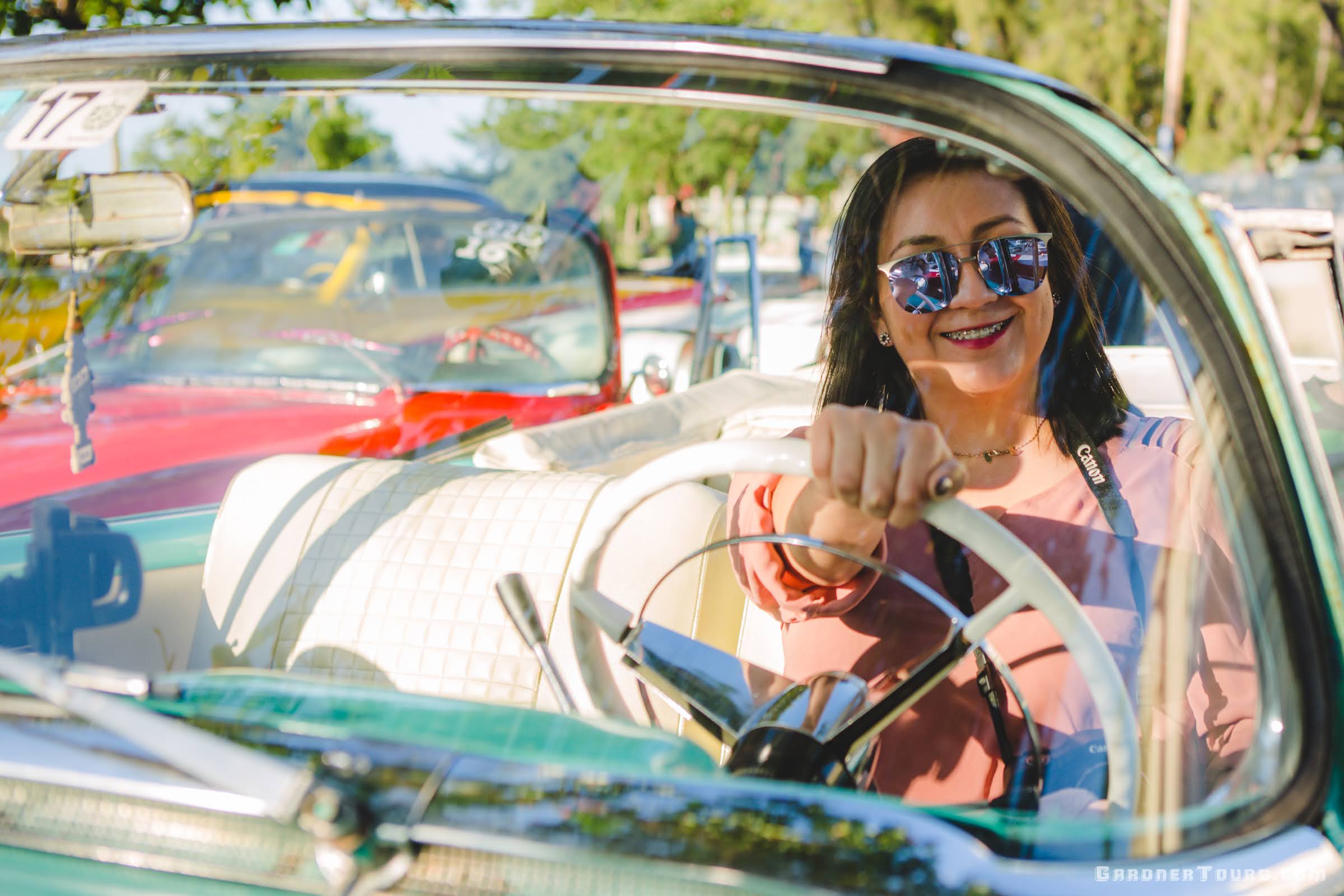 Mexican Woman with Sunglasses Sitting in a Classic Car in Havana, Cuba