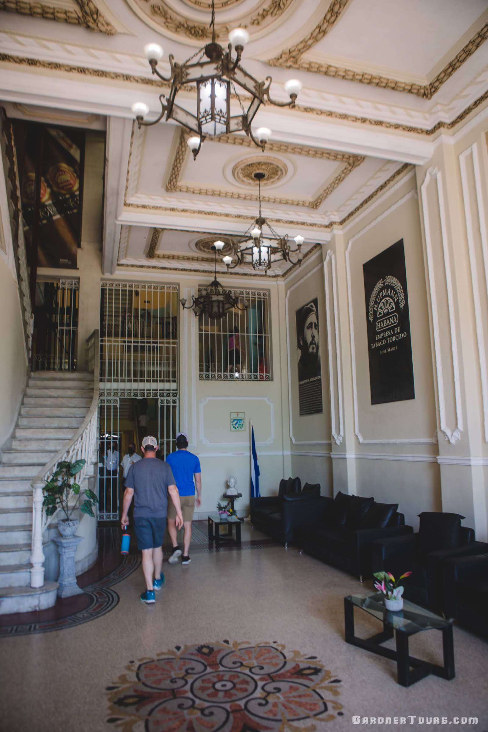 Two men Walking in the Lobby of the H. Upmann Cigar Factory in Havana, Cuba