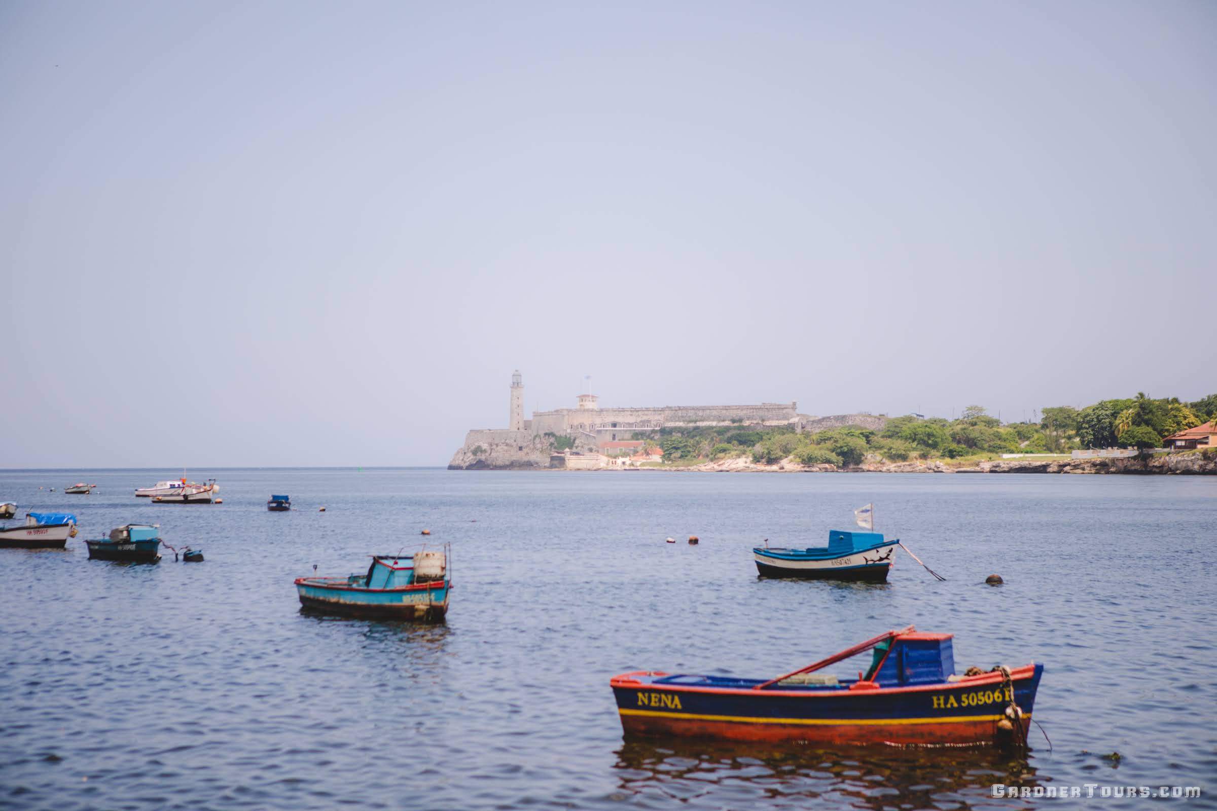 Colorful Fishing Boats in the Bay of Havana with El Morro Castle in the background in Cuba