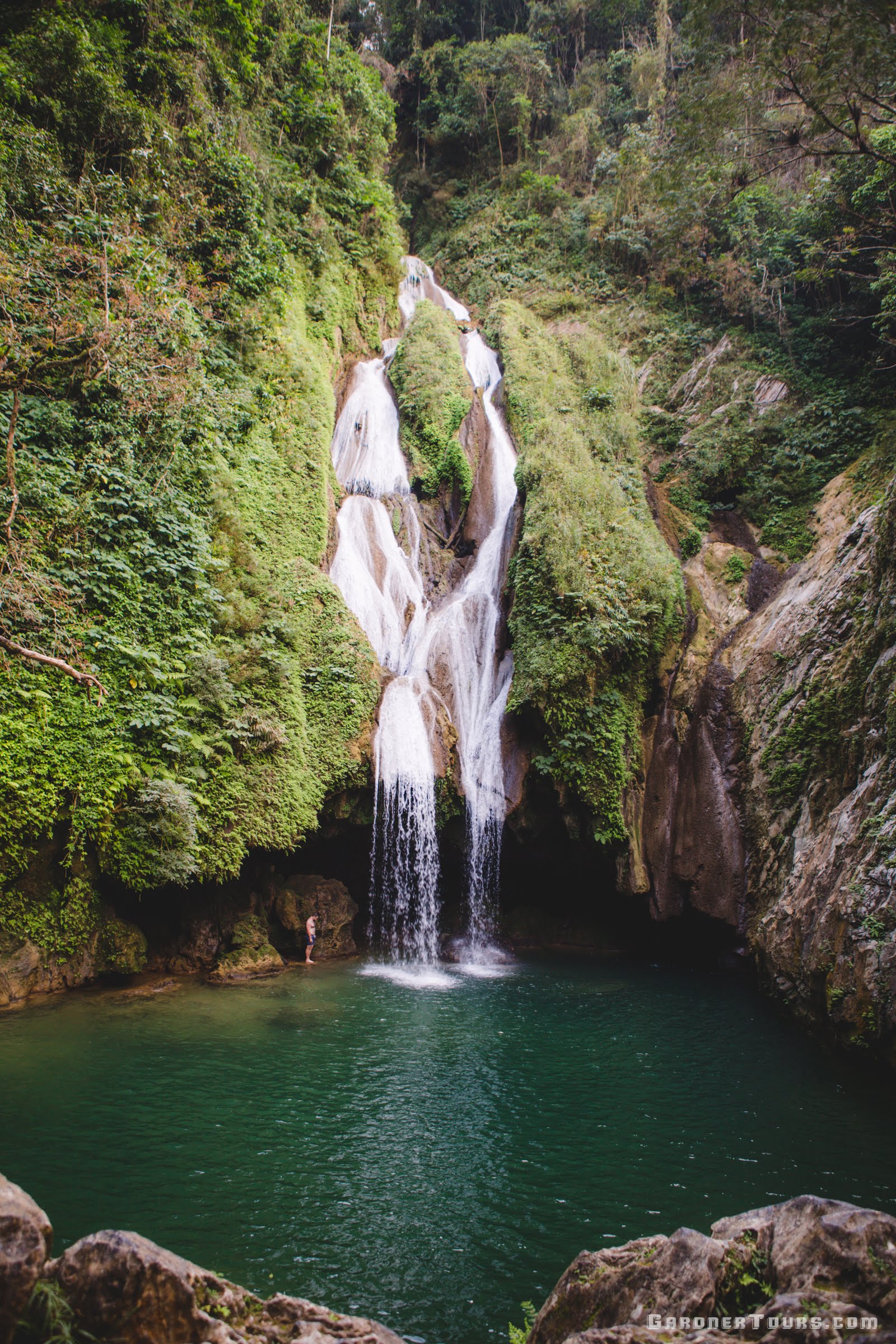 Man standing under Las Vegas Grande Waterfall in the Topes de Collantes National Park