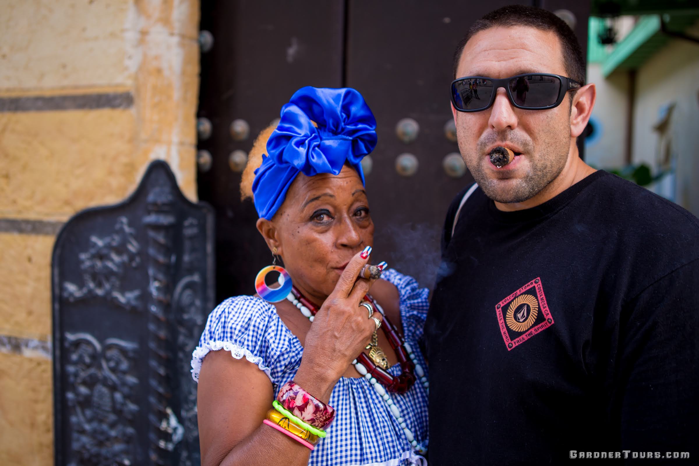 Black Cuban Woman With White Man Enjoying Cuban Cigars in Havana Cuba