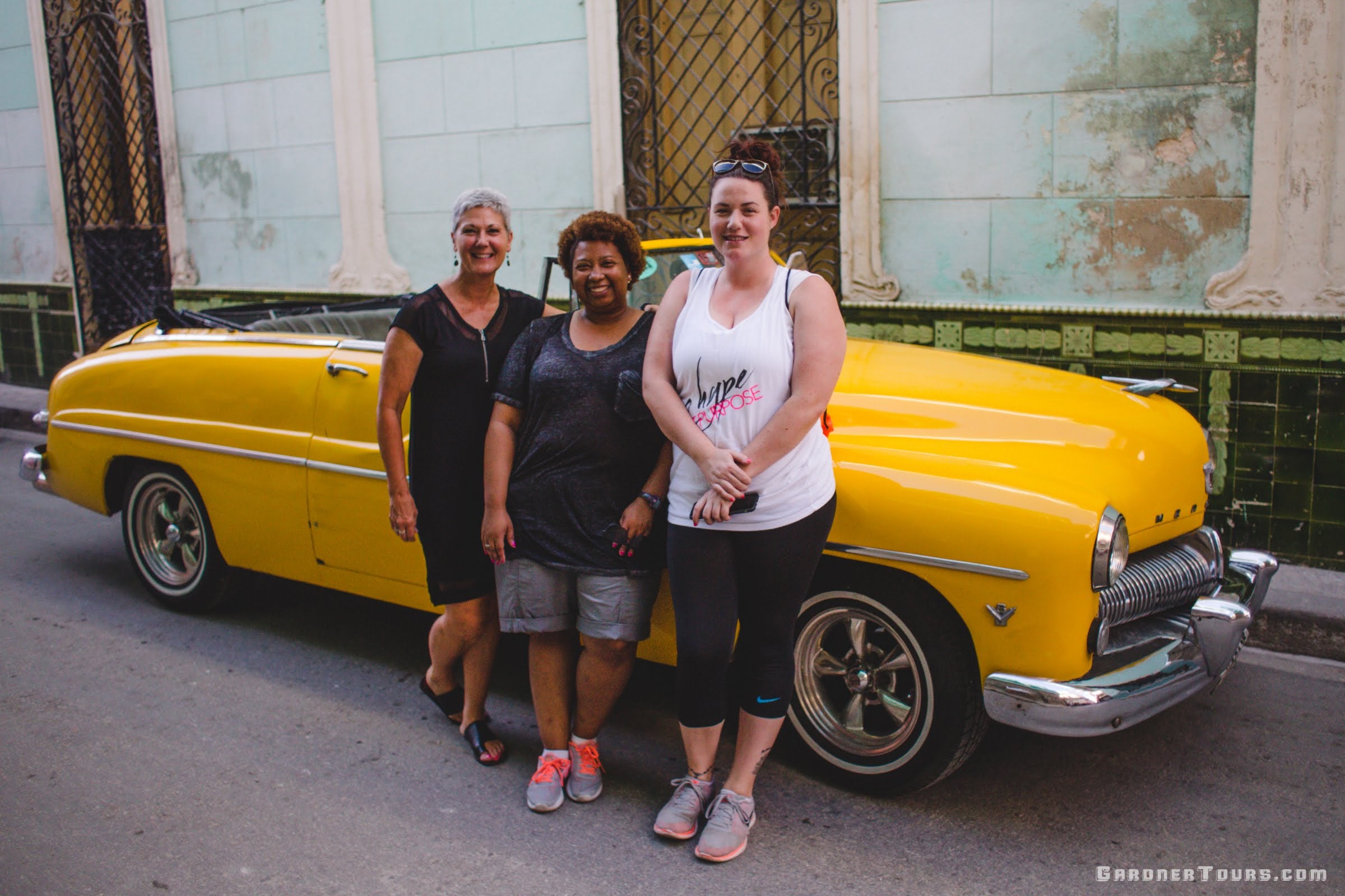 Three American Friends Standing in front of Yellow 1949 Mercury Convertible in Havana, Cuba