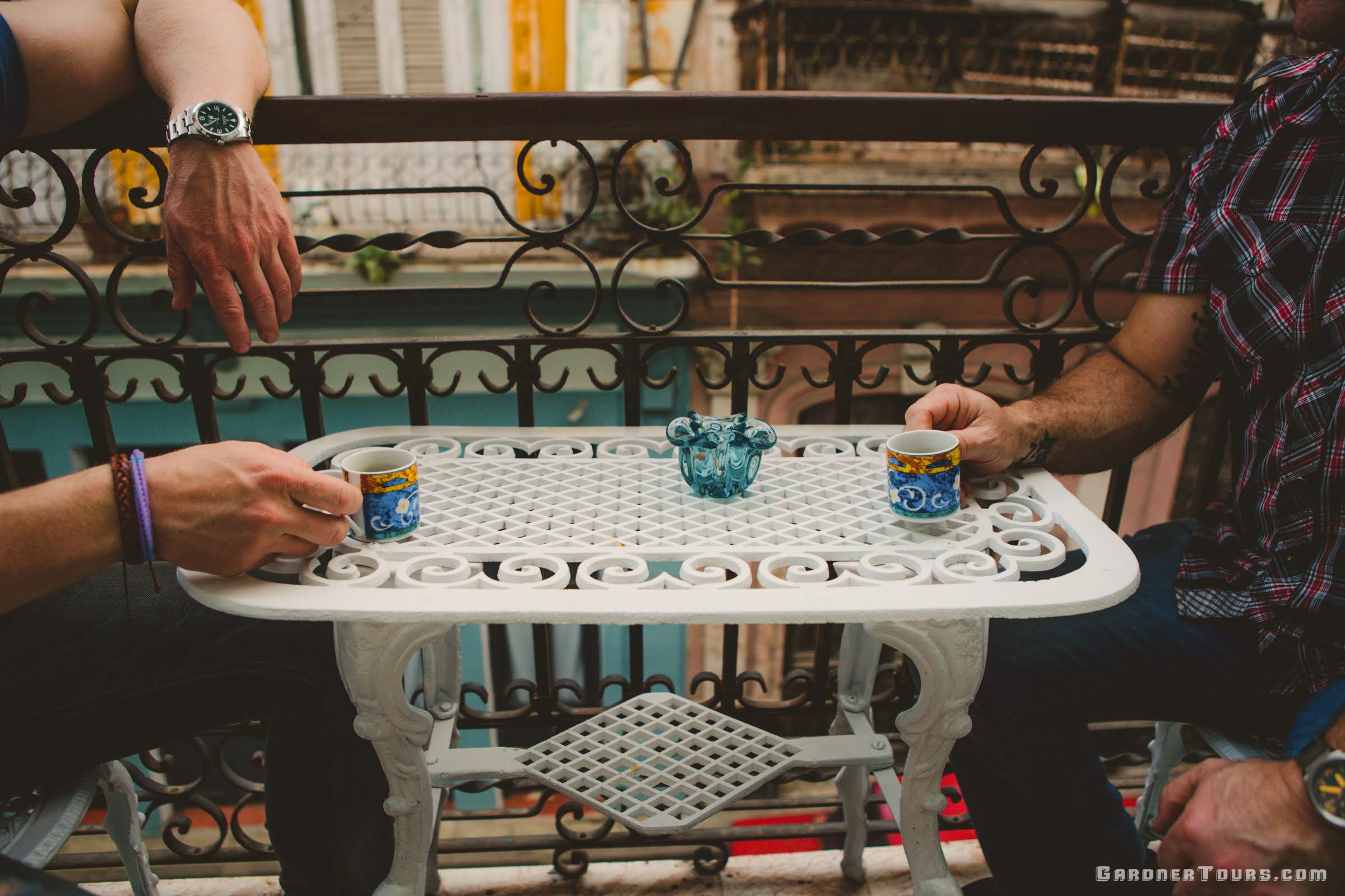 Two men sharing a Cuban Coffee early one morning on a balcony in Old Havana as the sun rises