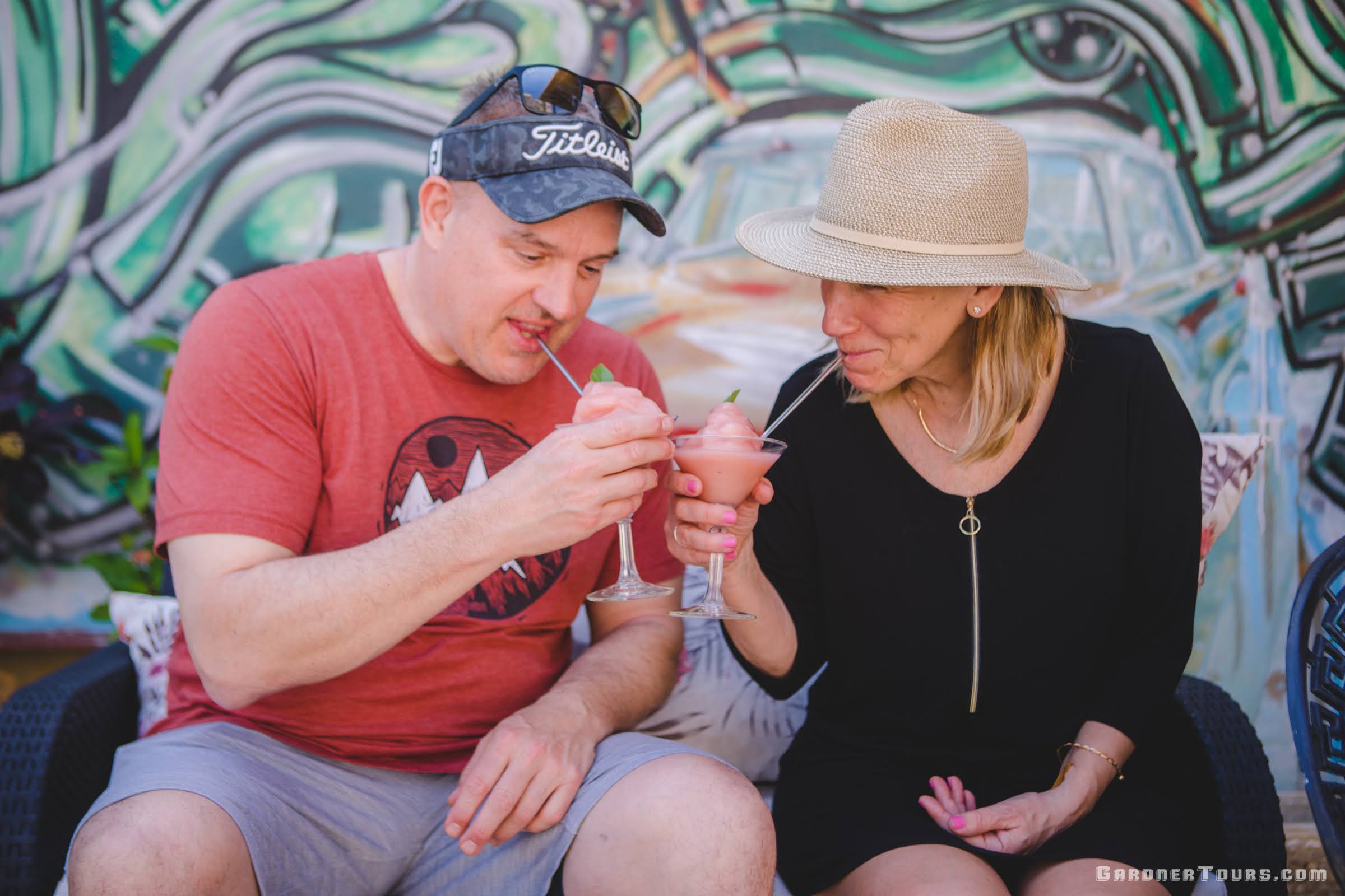 A Man and a Woman couple enjoying homemade strawberry frozen daiquiris on a Rooftop after a Cuban Cocktail Lesson in Old Havana, Cuba