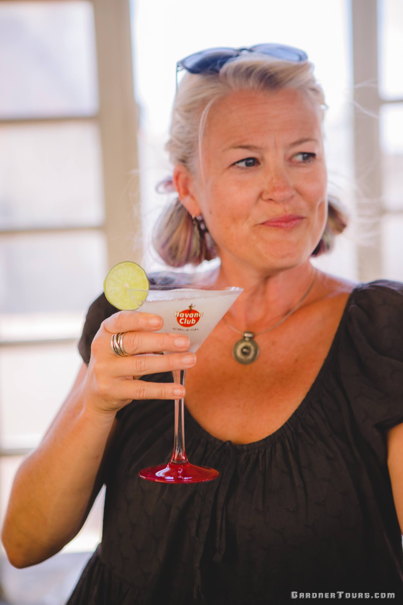 A Beautiful Woman in a black dress Drinking a Frozen Daiquiri on a Rooftop during a Cuban Cocktail Lesson in Old Havana, Cuba