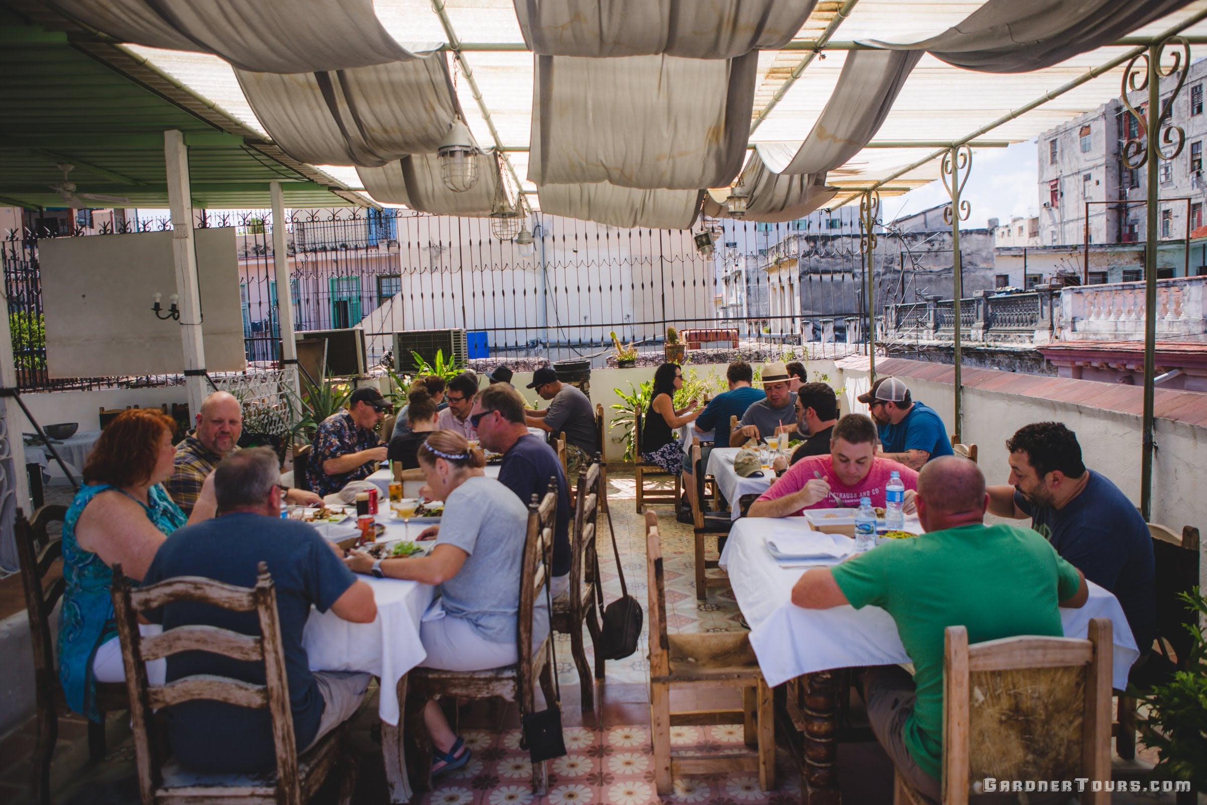 A large Group of friends eating Lunch on a Rooftop at a Restaurant Paladar in Old Havana, Cuba
