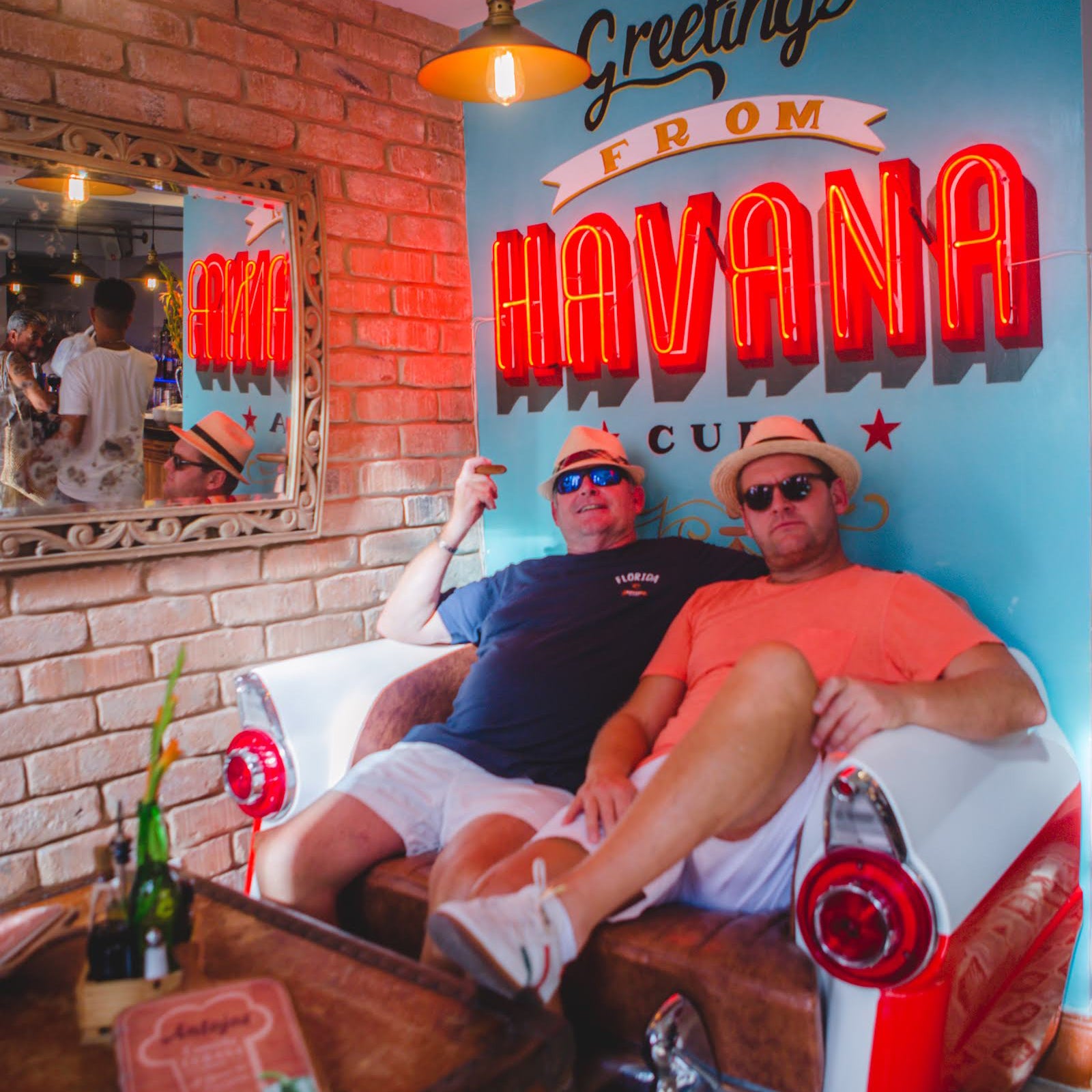 Gardner Tours Custom Cuba Tours Father and Son enjoy a cigar at the colorful Antojos Restaurant in Old Havana Cuba