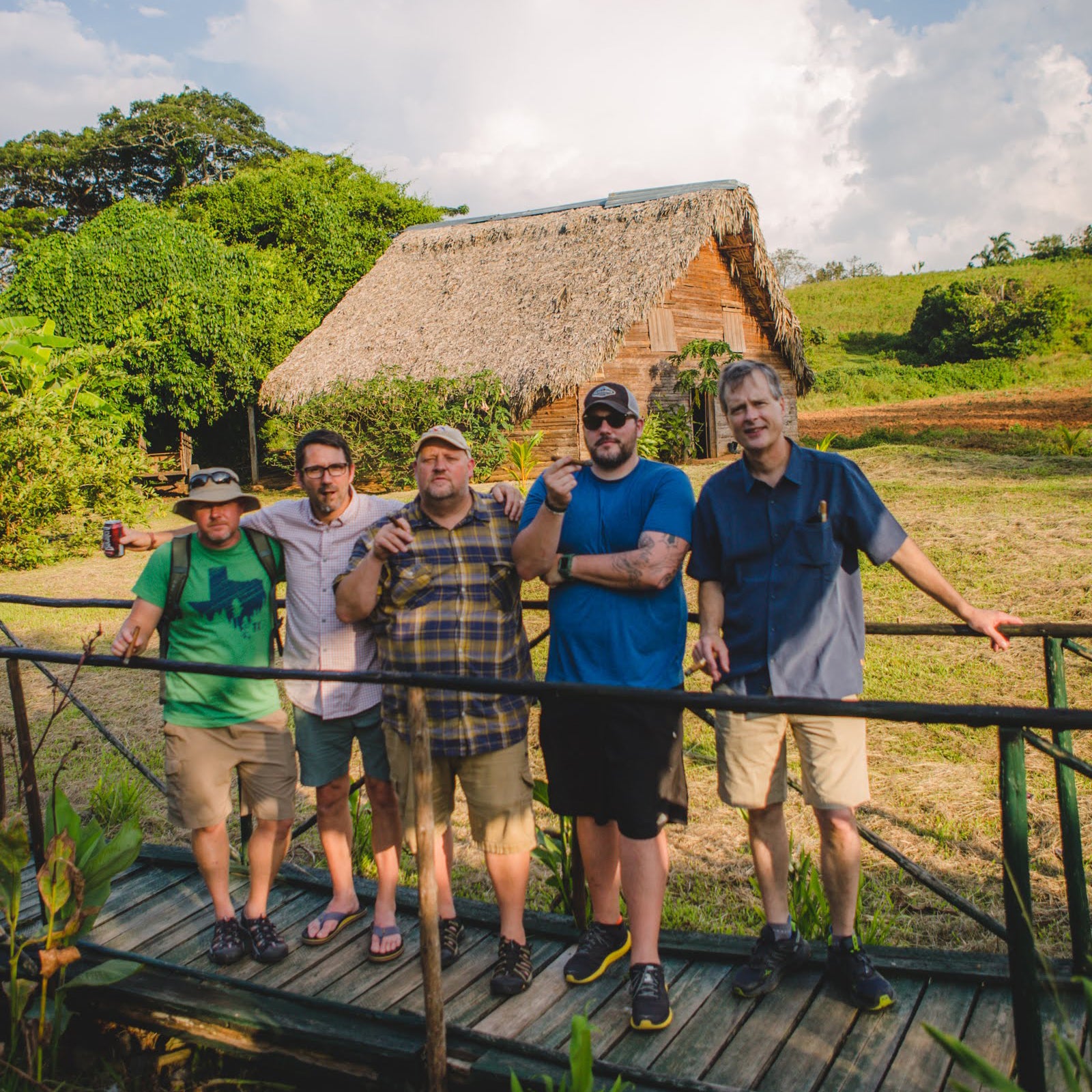 Gardner Tours Custom Cuba Tour Group of Men hanging out and smoking cigars on a Tobacco Farm in Vinales Cuba