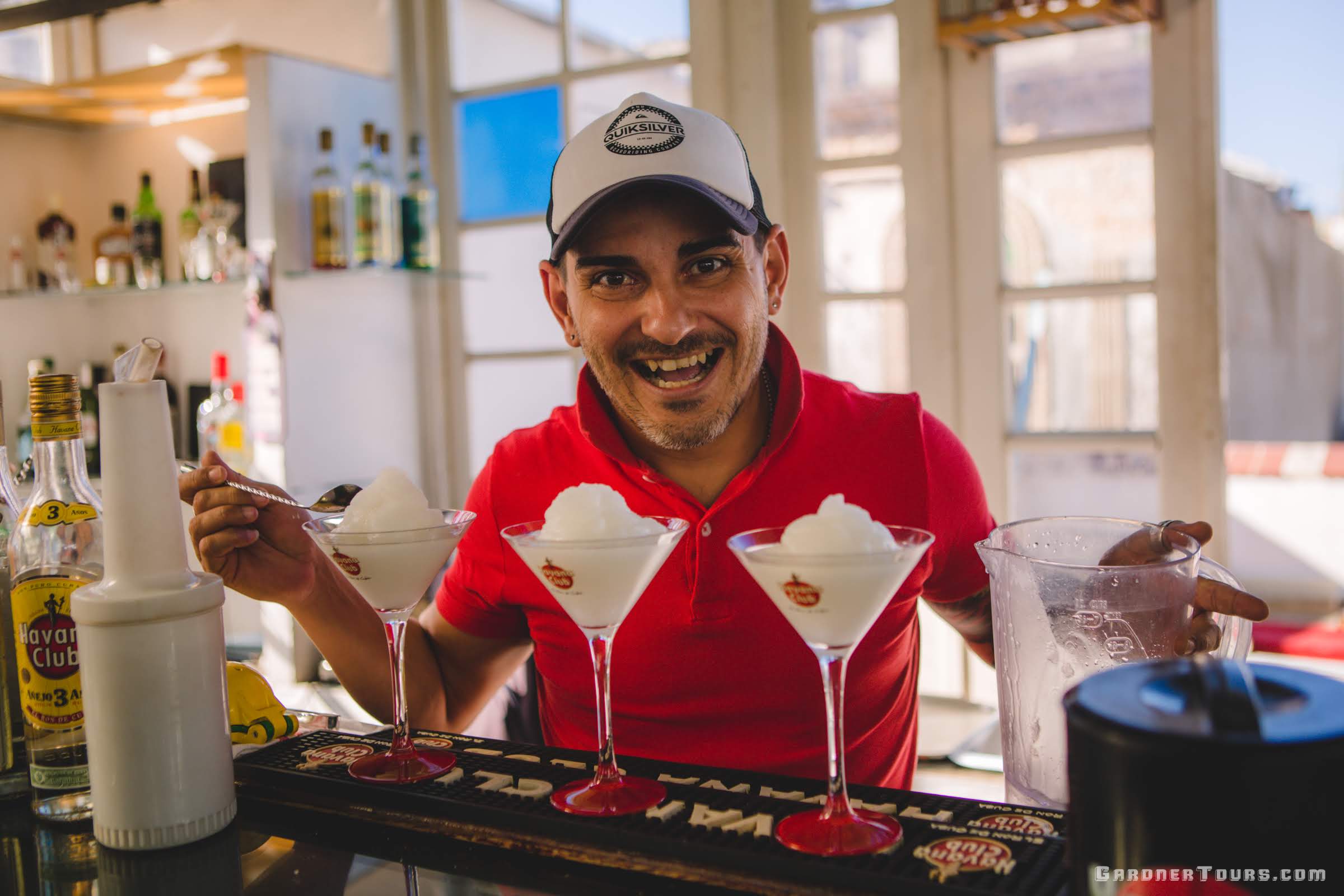 Bartender in Red Shirt Having Fun and Smiling Big while Making Cocktails in Havana, Cuba