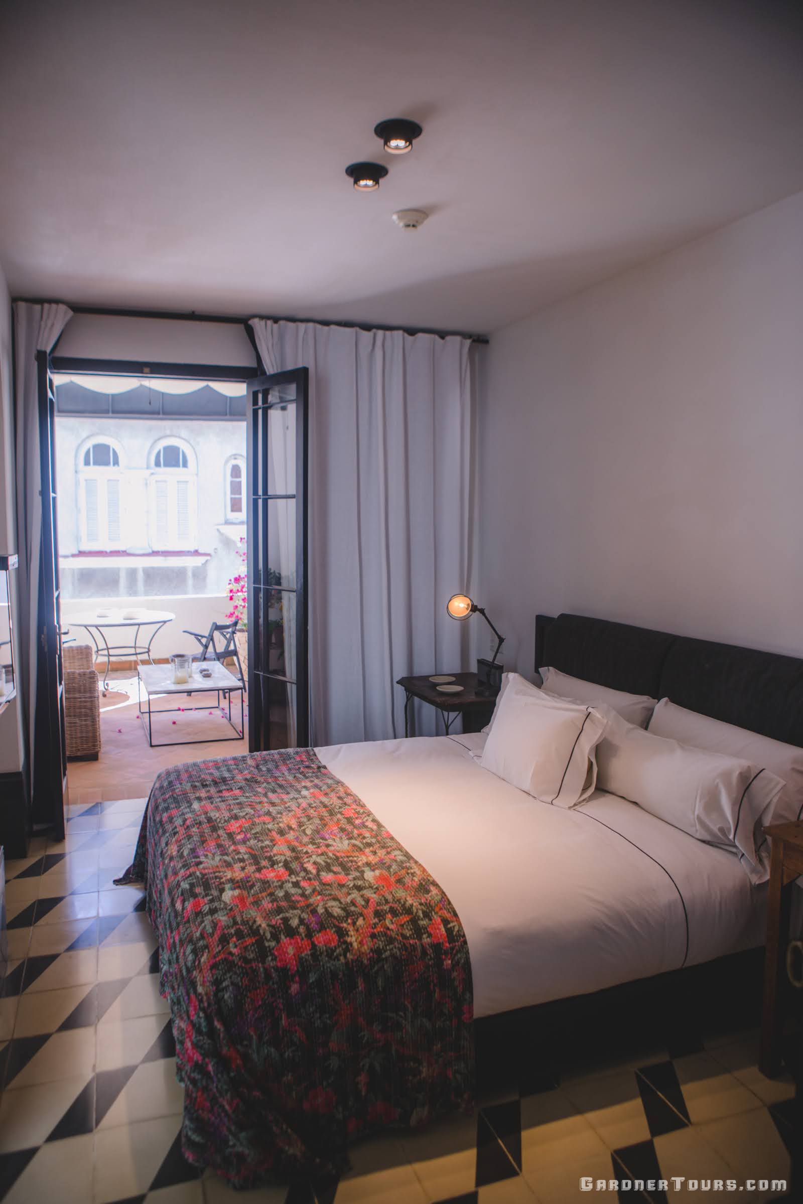 Luxury Bedroom with Lush Bed and Black, White, and Purple/Pink Flowered Decor and a Big Balcony at 5-star Luxury Accommodations in Old Havana, Cuba
