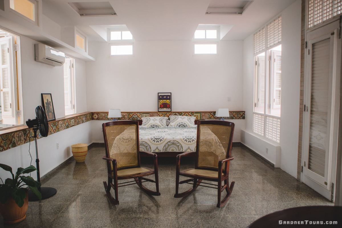 Gardner Tours spacious king size bed in a rooftop room with white walls and classic tiles at a 4-star BnB Casa Particular in Old Havana, Cuba