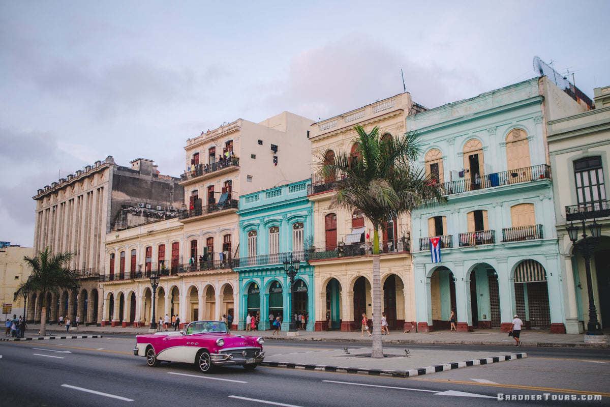 Pink and White Buick Convertible Classic Car in front of Colorful Buildings at KM Zero in Havana, Cuba