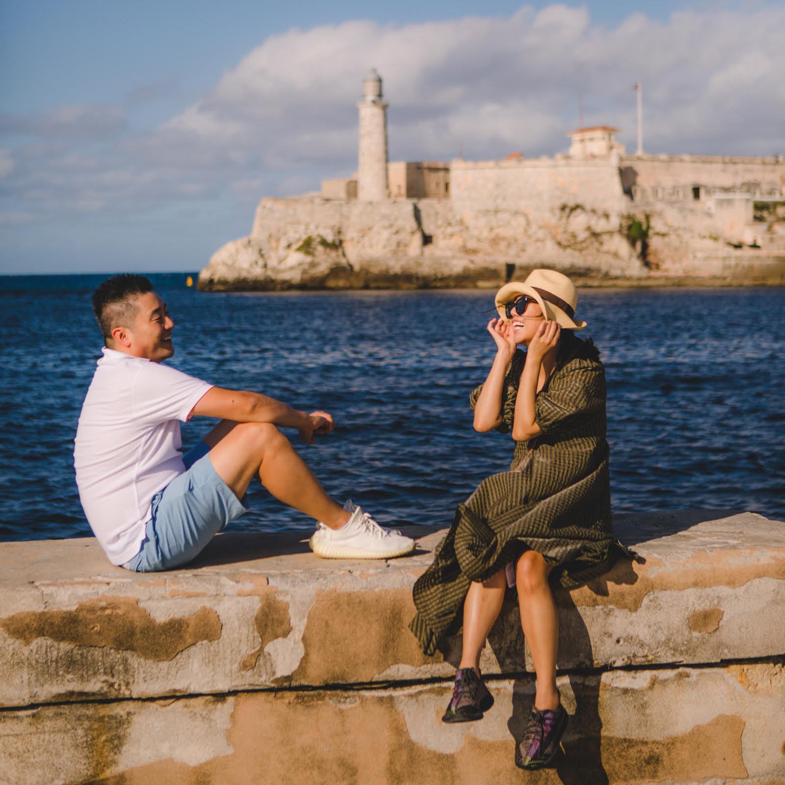 Gardner Tours Cuba Tours Havana Long Weekend Tour 5 Star TripAdvisor Review by Harim and Stephanie Kim who are sitting on the malecon across from the El Morro Castle