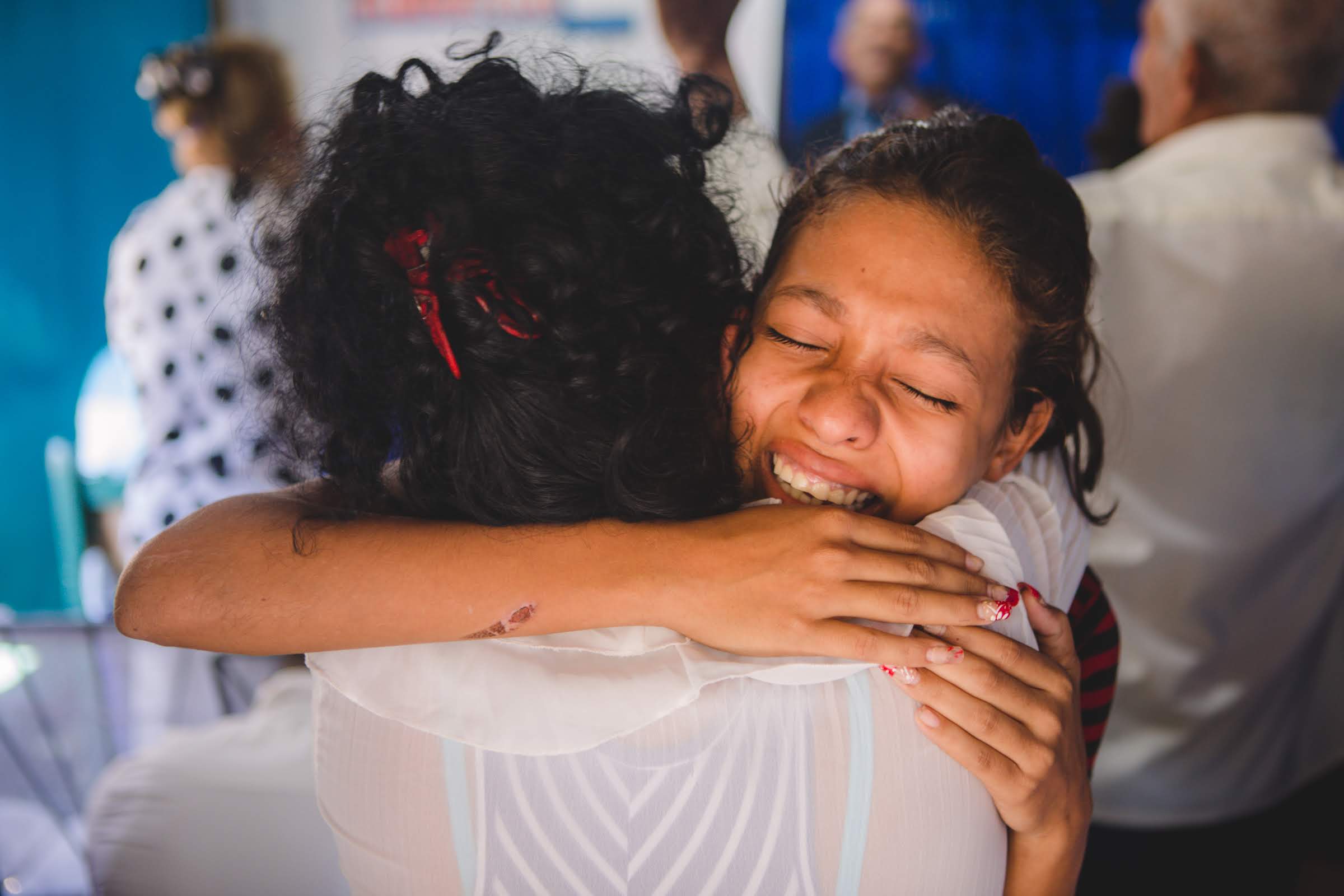 Young Cuban Woman Crying with Gratitude and Hugging a Friend