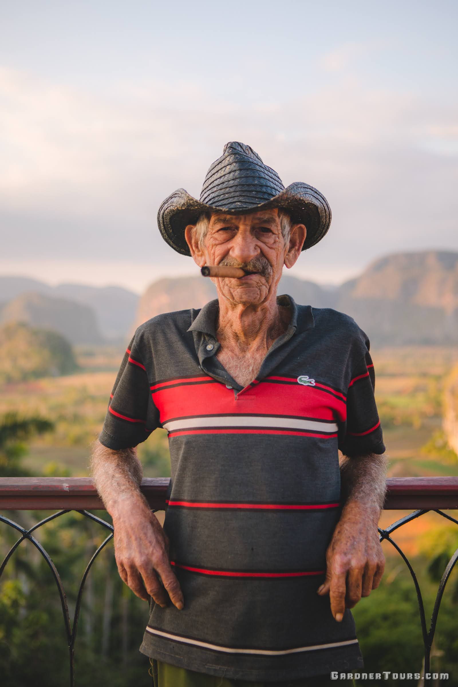 Elderly Cuban man Miguel smoking a cigar at the Los Jazmines Hotel Viewpoint over the Viñales Valley in Viñales, Cuba