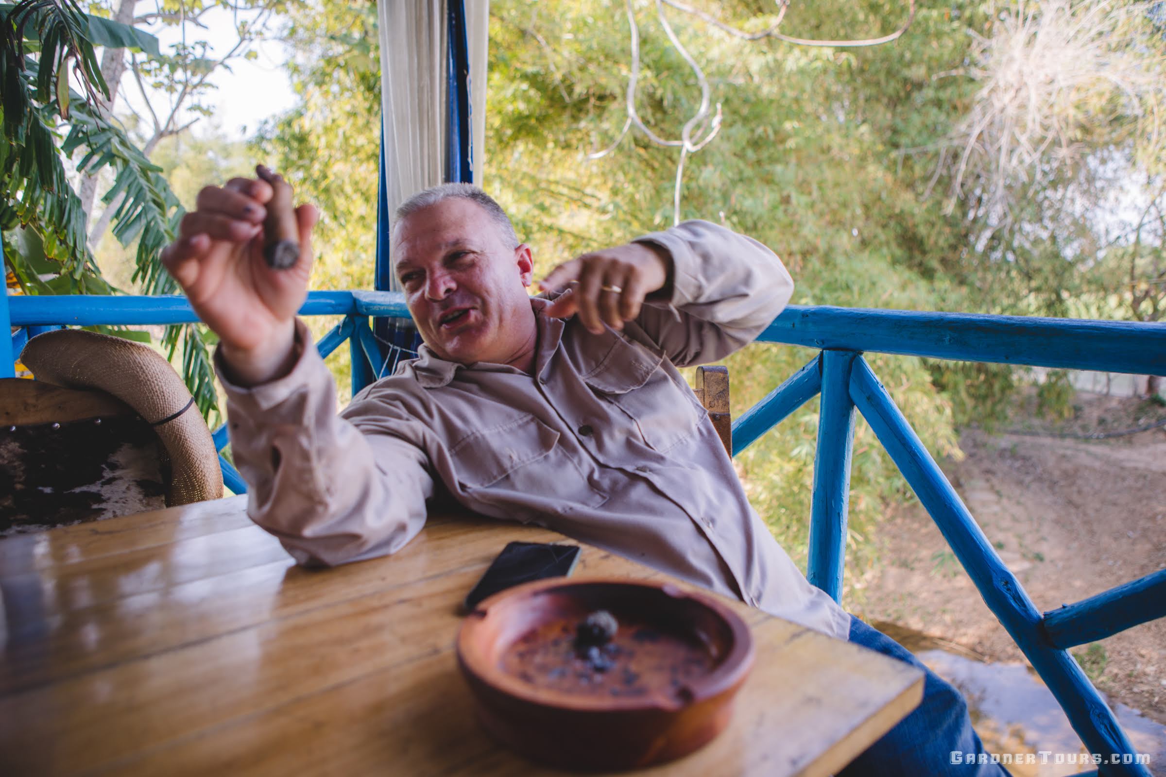 Hector Luis Prieto Hombre del Habanos Tobacco Farmer smoking a cigar and laughing with friends on his farm in Pinar del Rio, Cuba