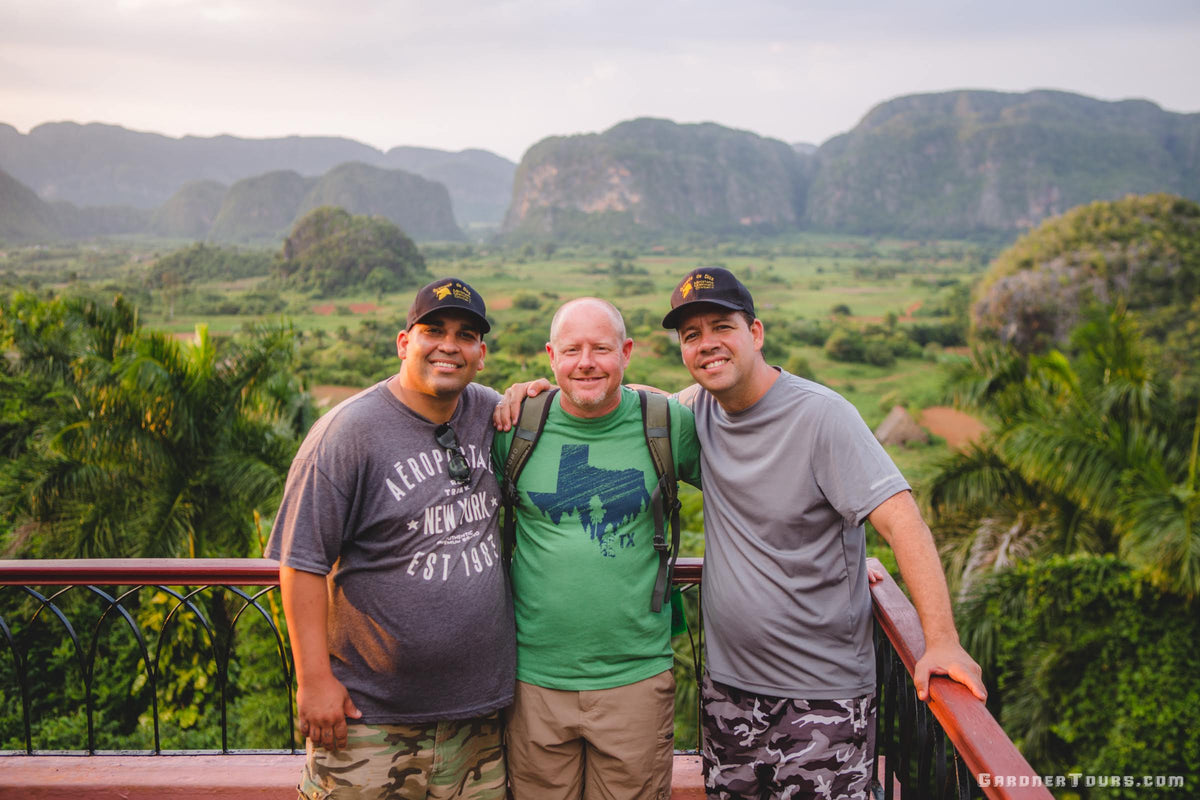 Gardner Tours Cuban Tour Guide Yunior and Albert smiling with a friend at the Viewpoint overlooking Viñales Valley in Cuba landscape photo