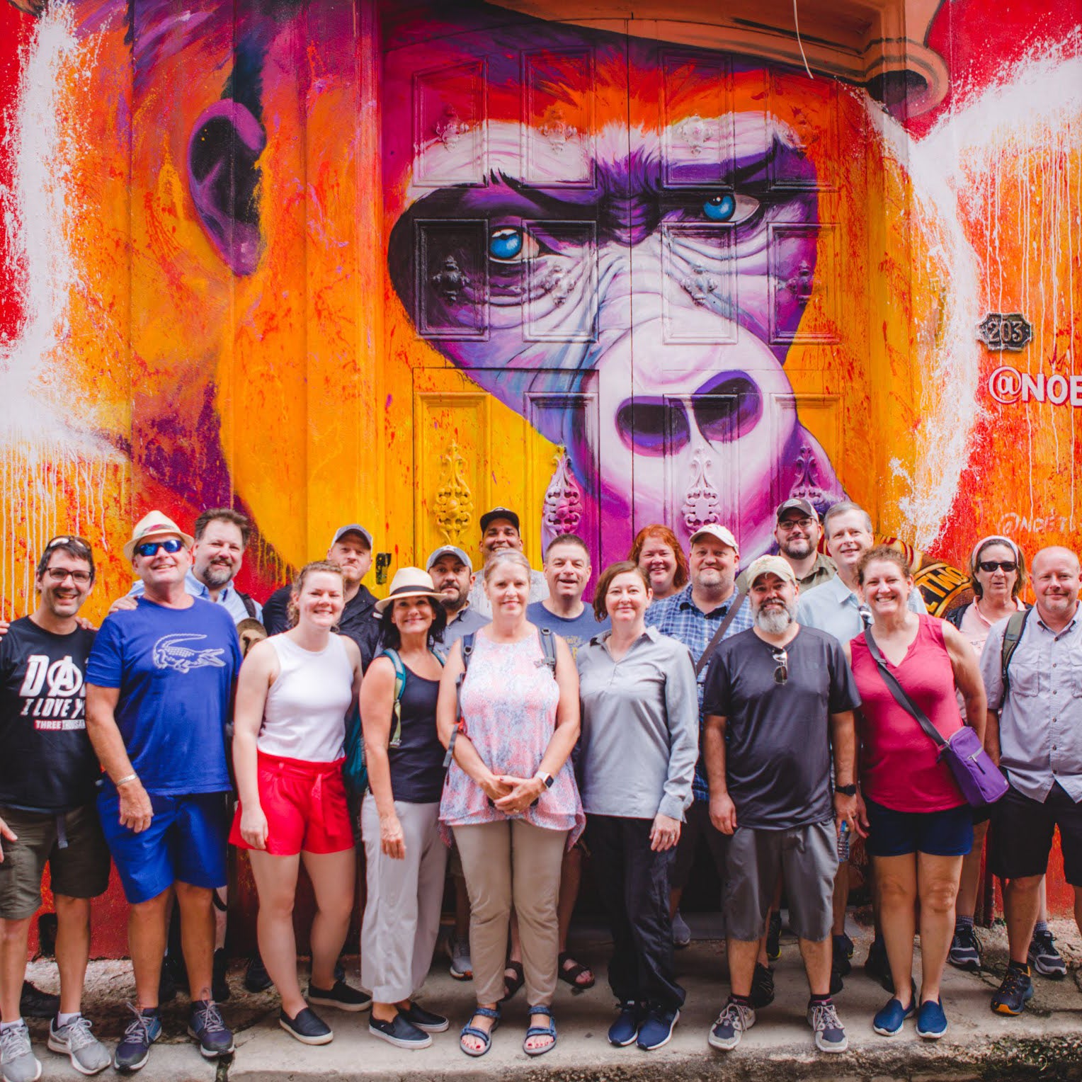 Large Group of Professional Tour Guides on their Custom Cuba Tour with Gardner Tours, all together in front of a painted door with a gorilla in Old Havana Cuba