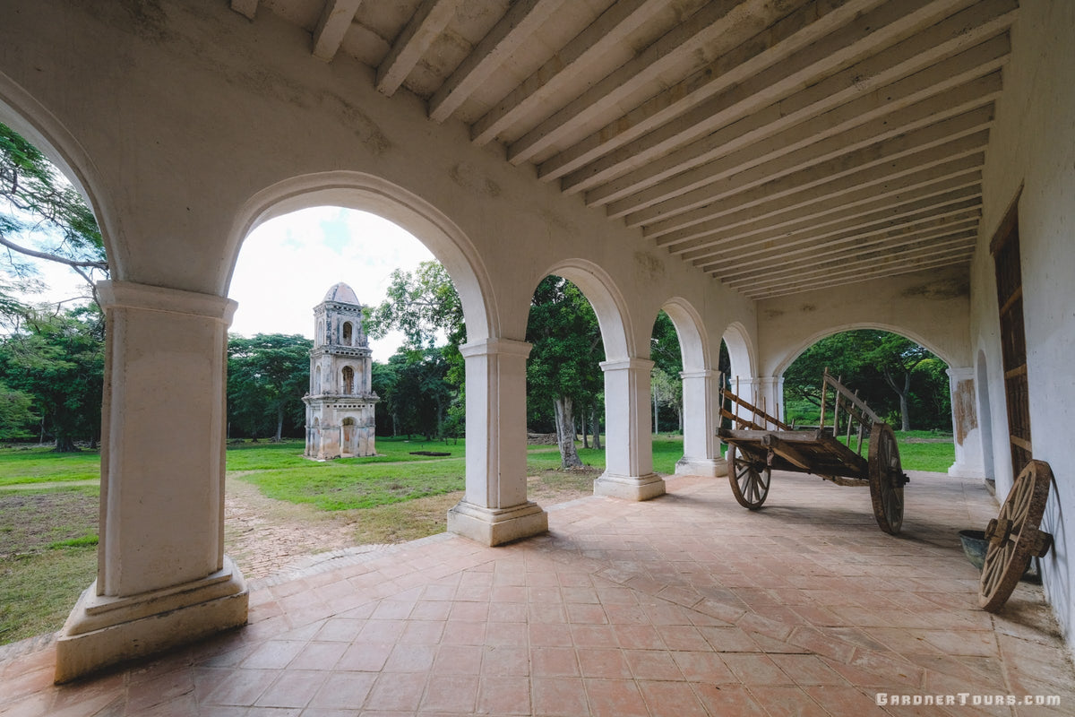 A peaceful perspective of the historic Ingenio San Isidro de los Destiladeros in Trinidad, Cuba, captured through white architectural arches—representing the Gardner Tours commitment to slow travel and authentic heritage.
