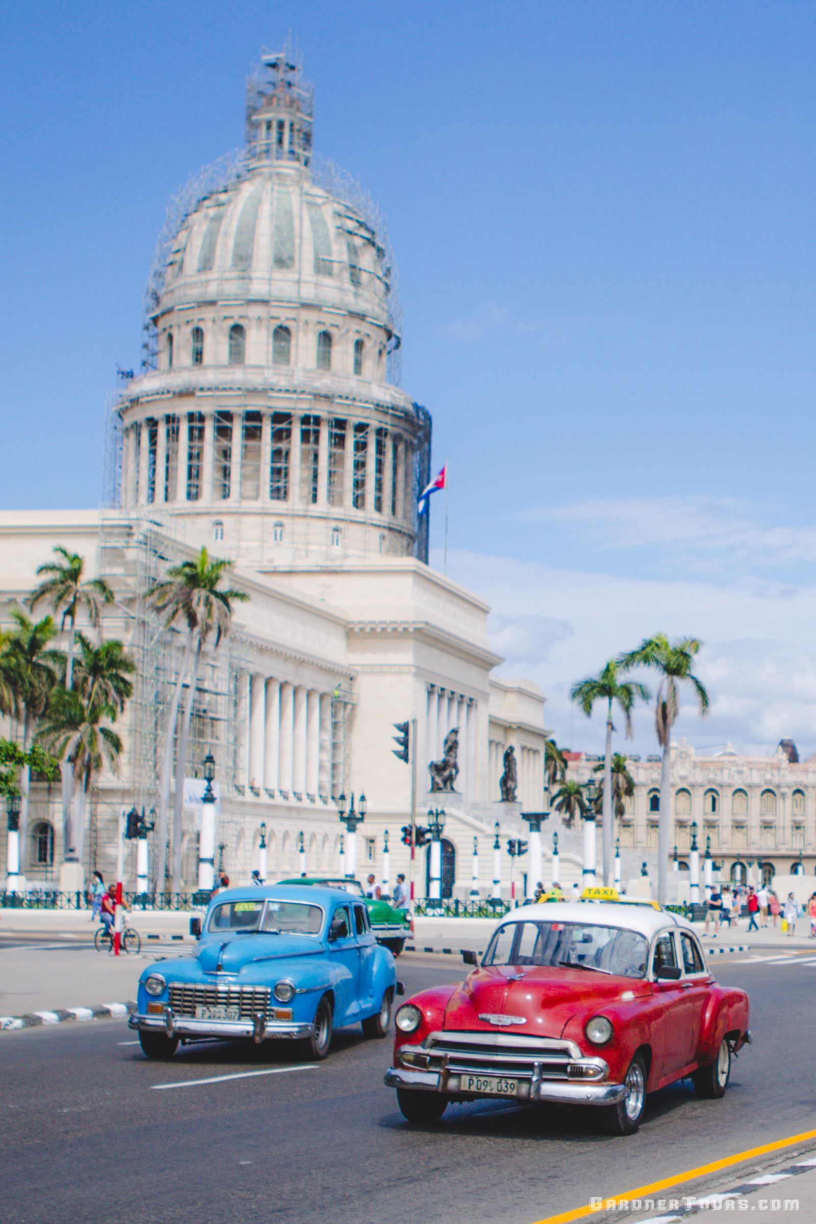 A small group of travelers enjoying a private boutique tour in Havana, Cuba, walking past the Capitolio in the sunshine with Gardner Tours.