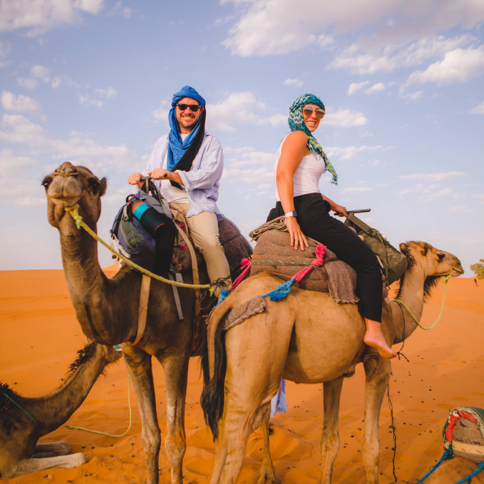 Couple experiencing a private camel trek through the Sahara Desert as part of Gardner Tours’ premier Best of Morocco Tour.