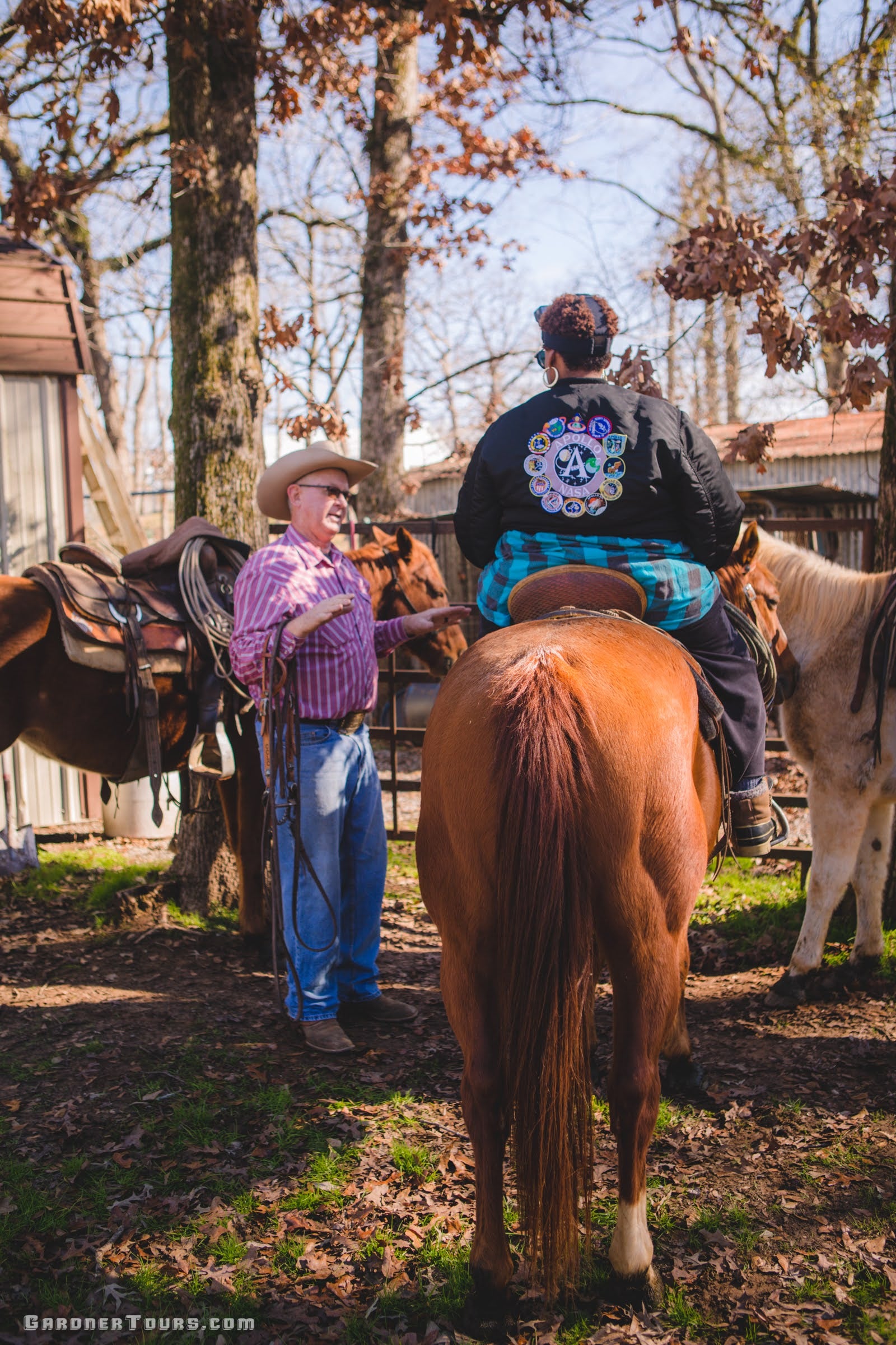Older cowboy explaining to a woman how to ride a horse on a ranch outside Centerville.