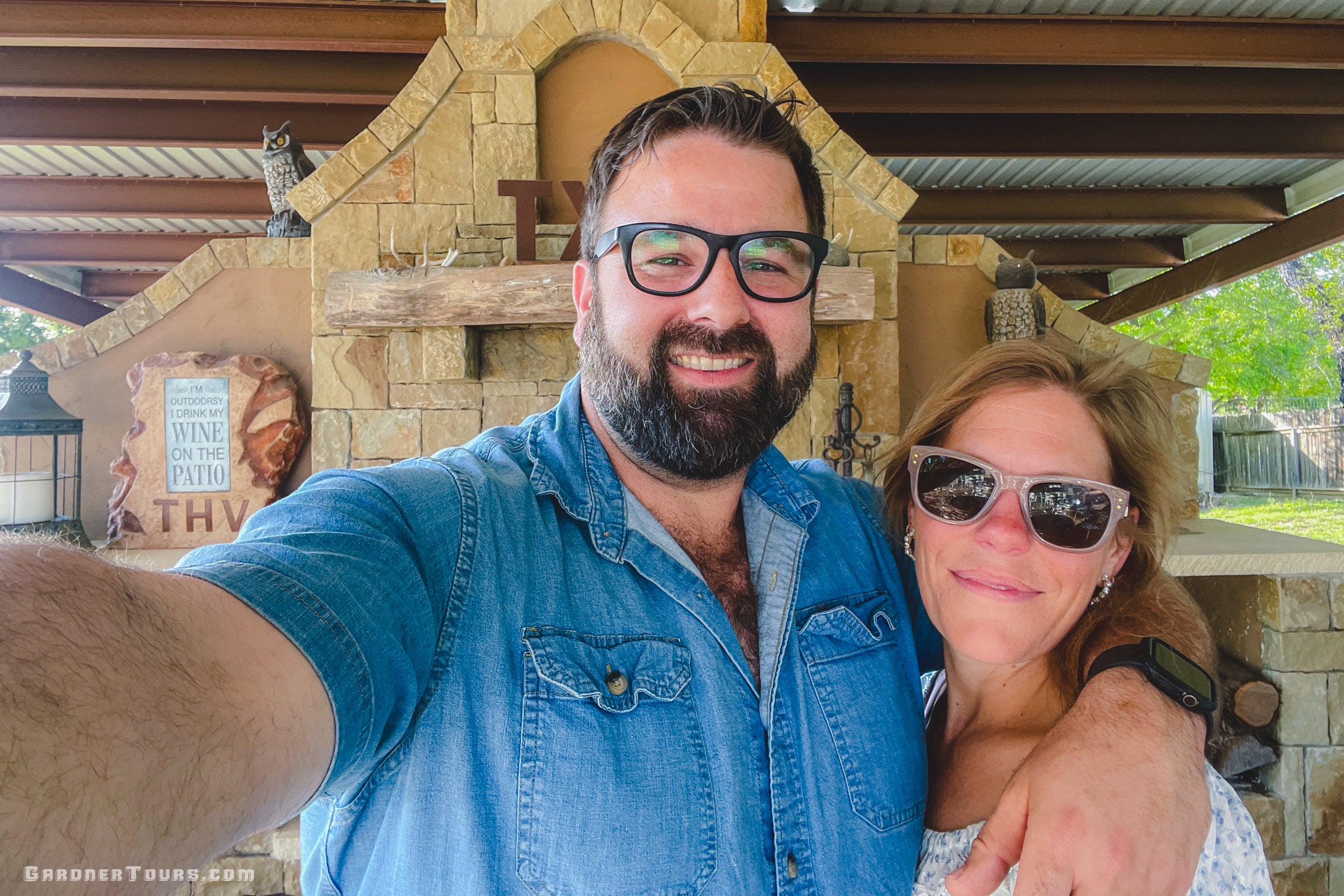 Couple taking a selfie by the fireplace at Texas Heritage Vineyards in Fredericksburg during the Texas Traditions Tour.