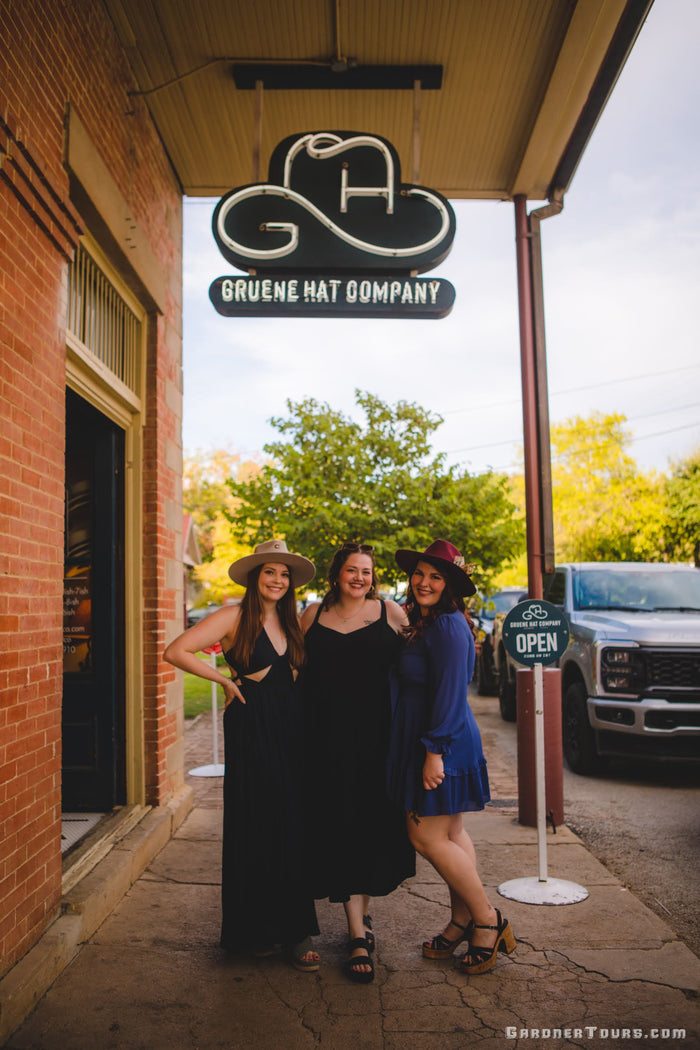 Three women posing with new cowboy hats at Gruene Hat Company near New Braunfels, Texas.